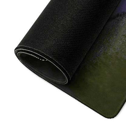 Rolled black gaming mouse pad with textured surface and stitched edges on dark background.