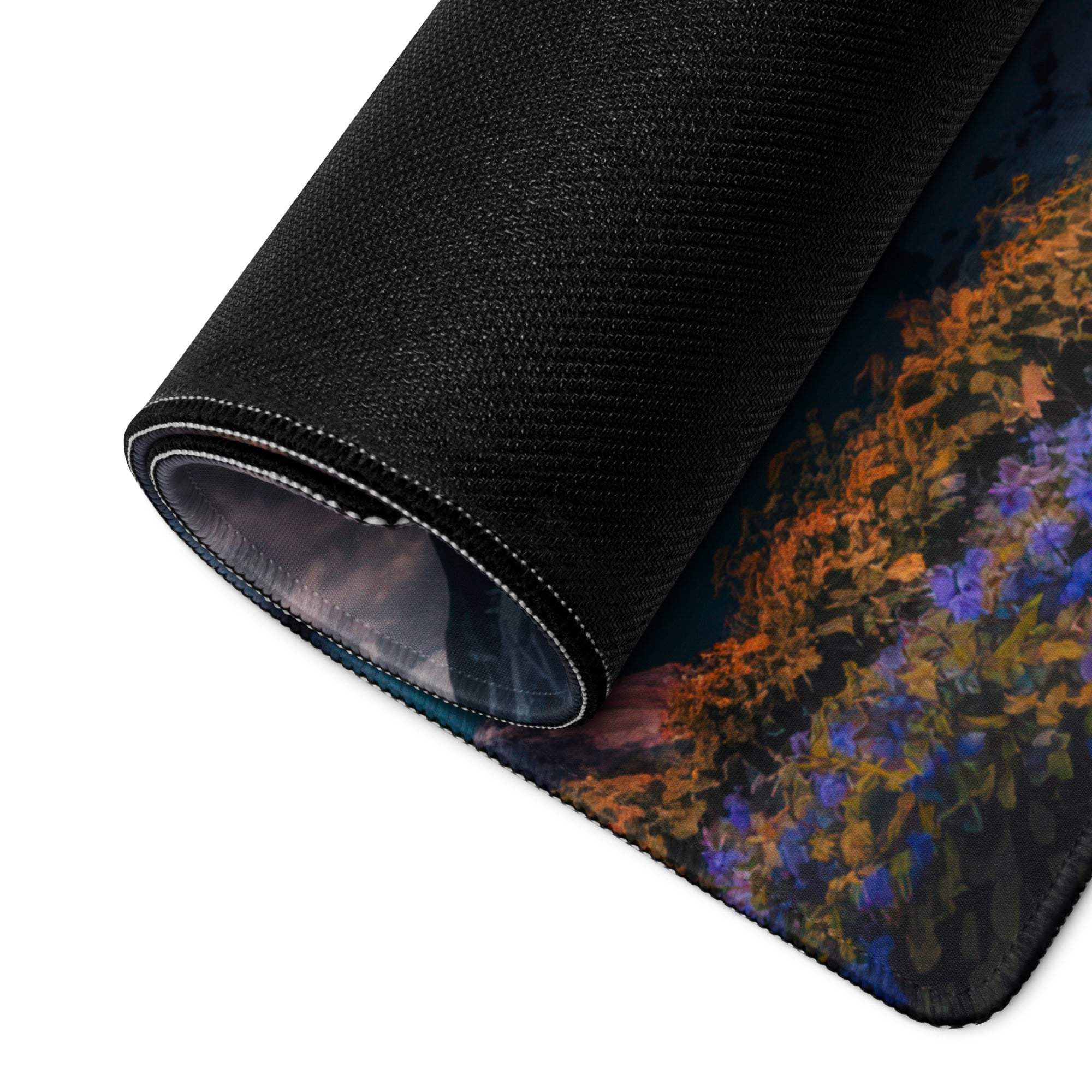 Rolled-up black gaming mousepad with vibrant purple orange floral design