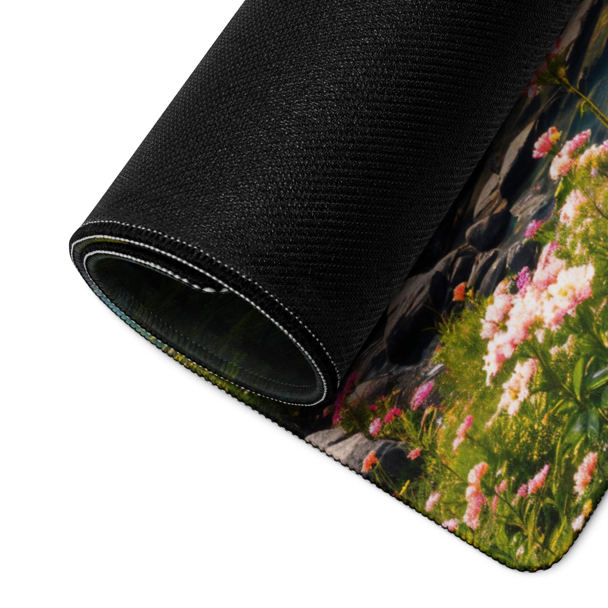 Black textured mousepad with pink floral blossoms by rocks