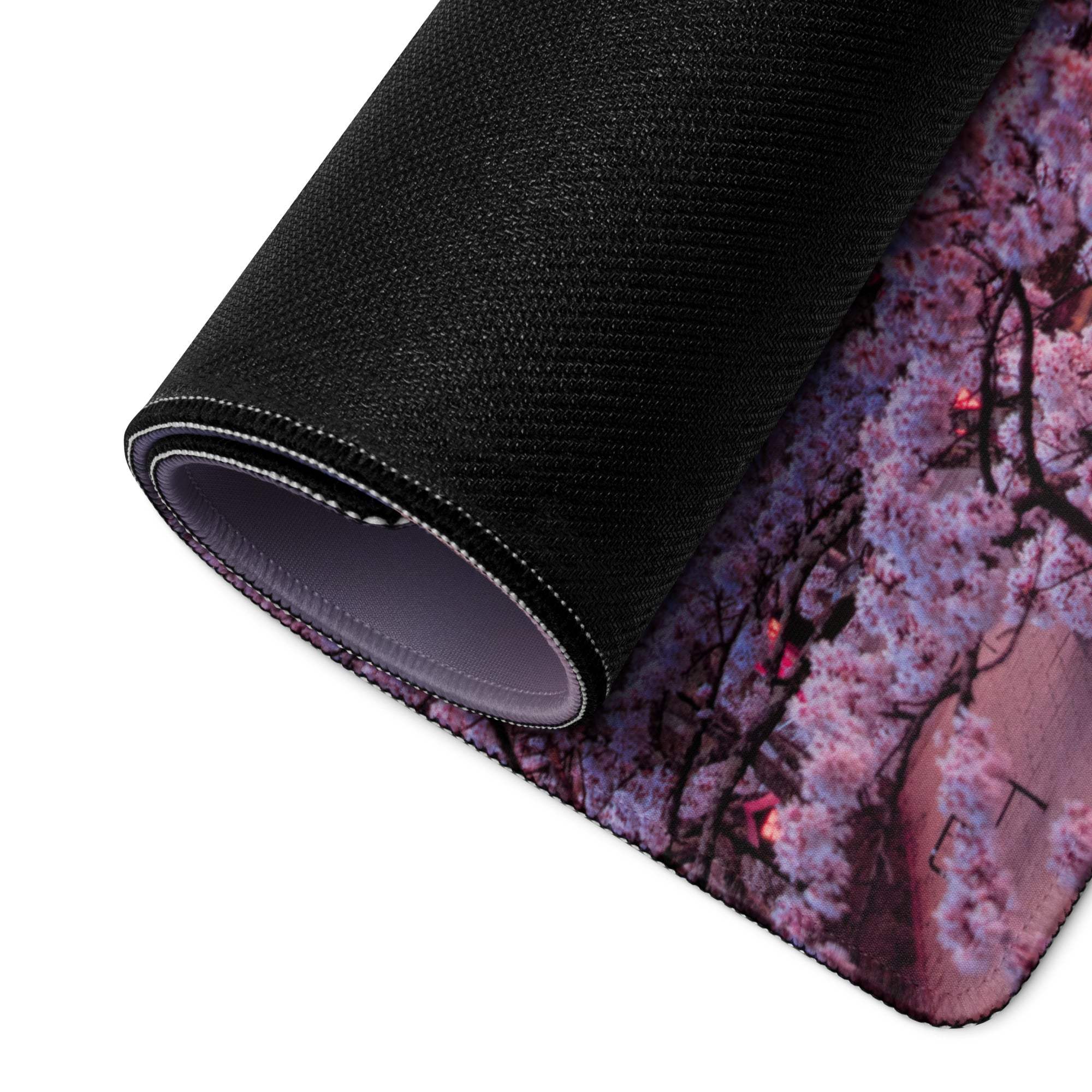 Rolled-up black gaming mousepad with pink sakura landscape design