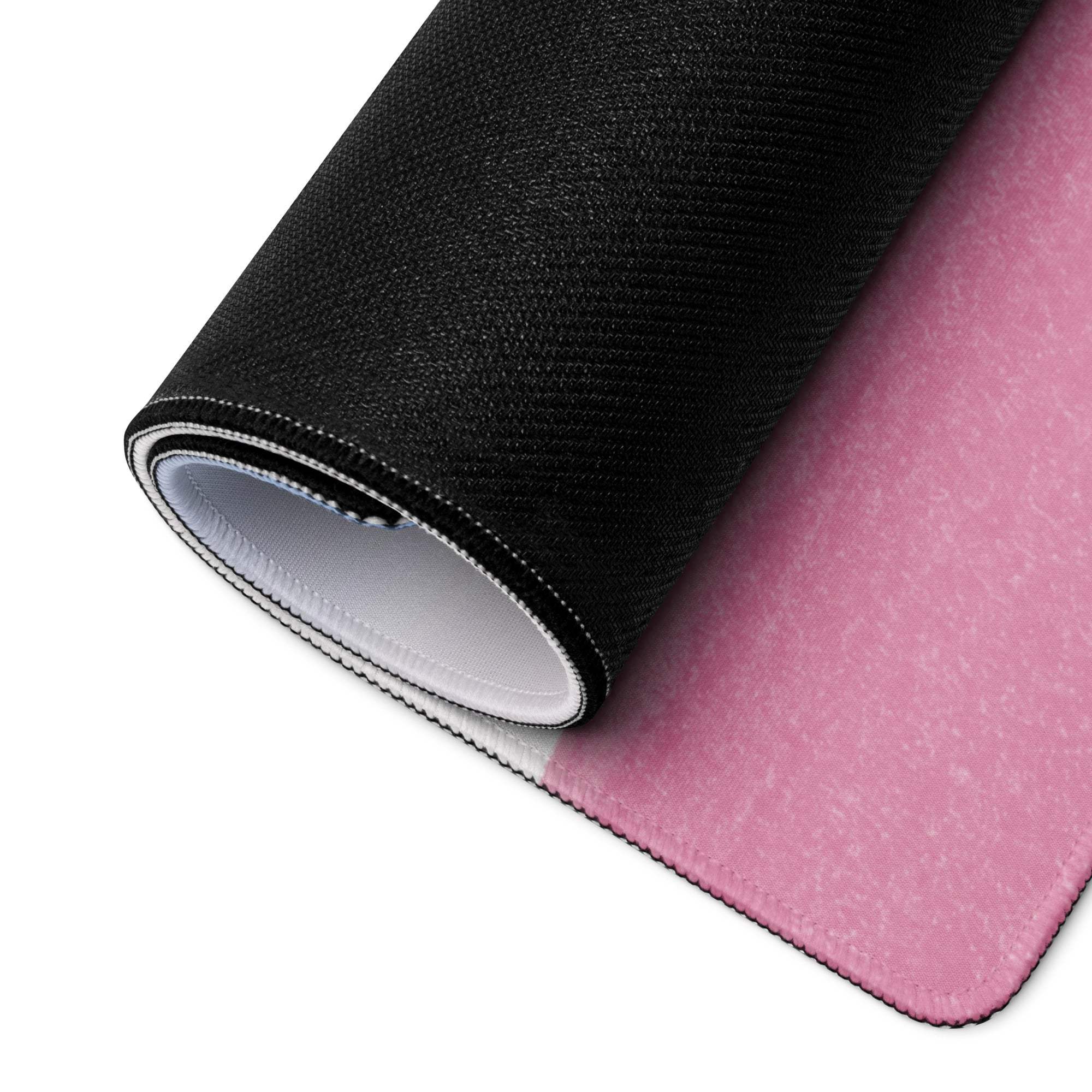 Large pastel pink gaming mouse pad rolled up with non-slip base and stitched edges