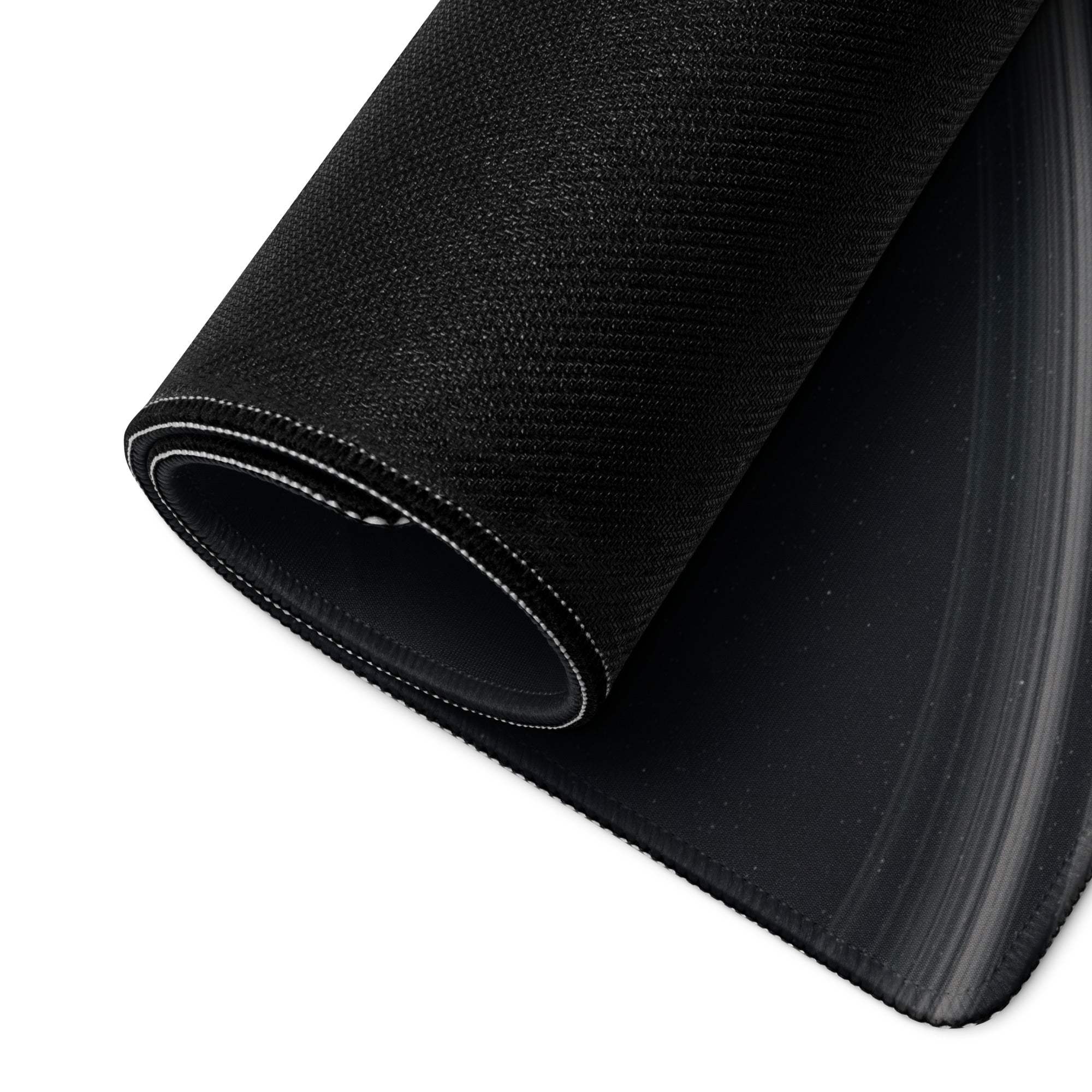 Black textured fabric roll with white edge stitching on cosmic space gaming mouse pad