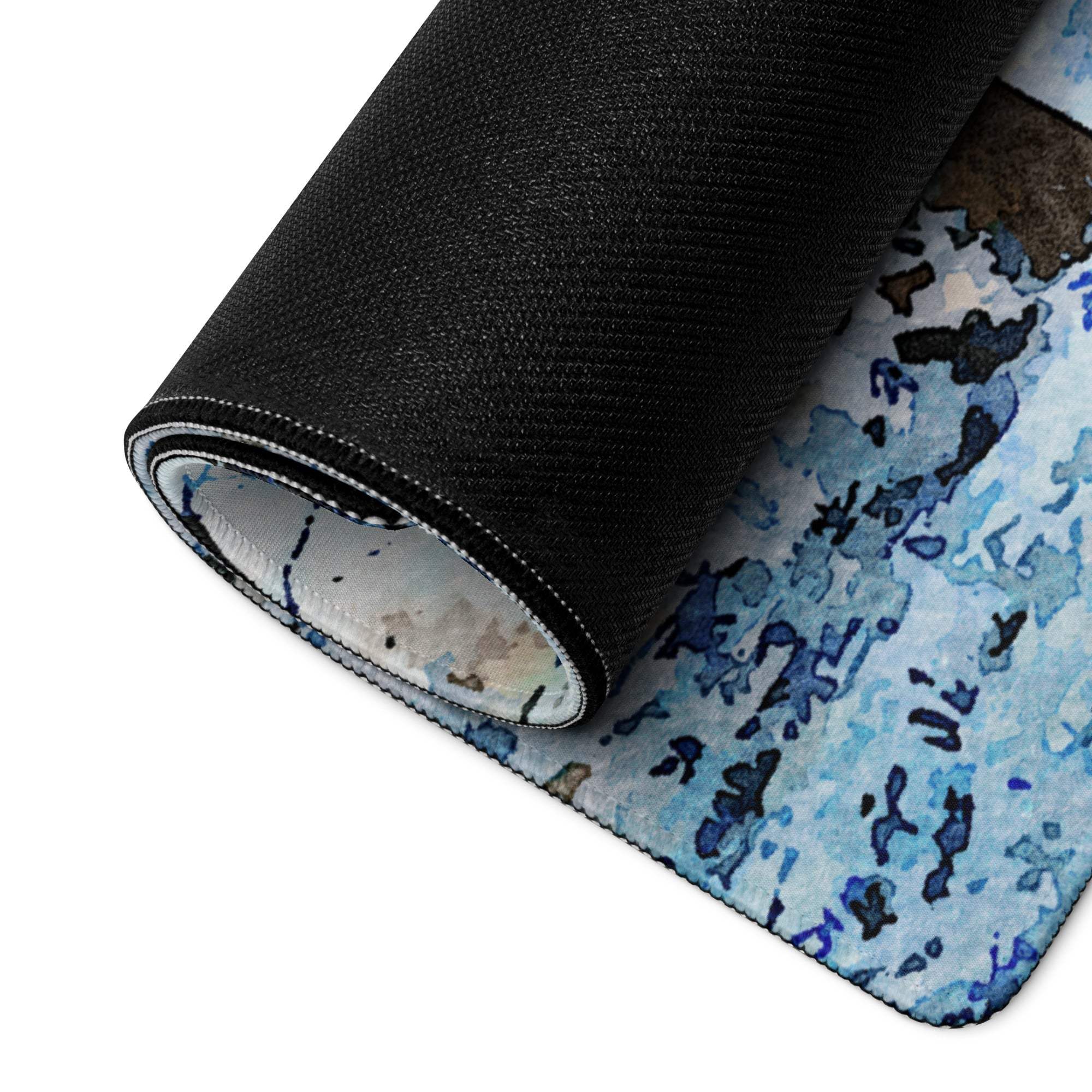 Rolled-up Winter Forest gaming mouse pad with blue watercolor design