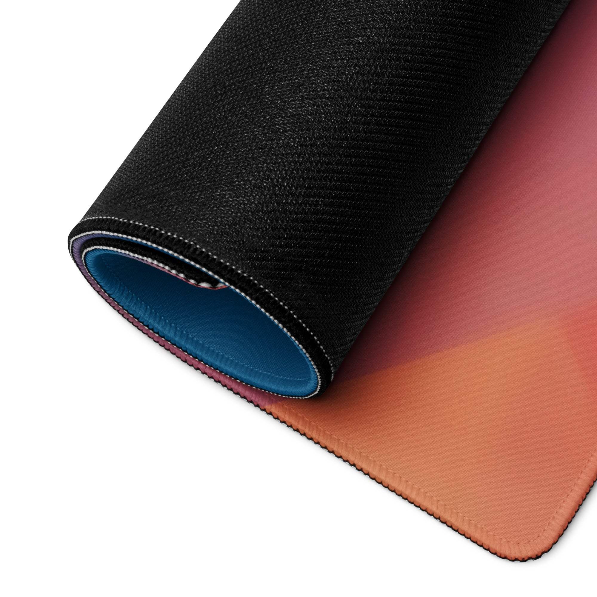 Black textured gaming mouse pad with orange-to-pink gradient and blue lining
