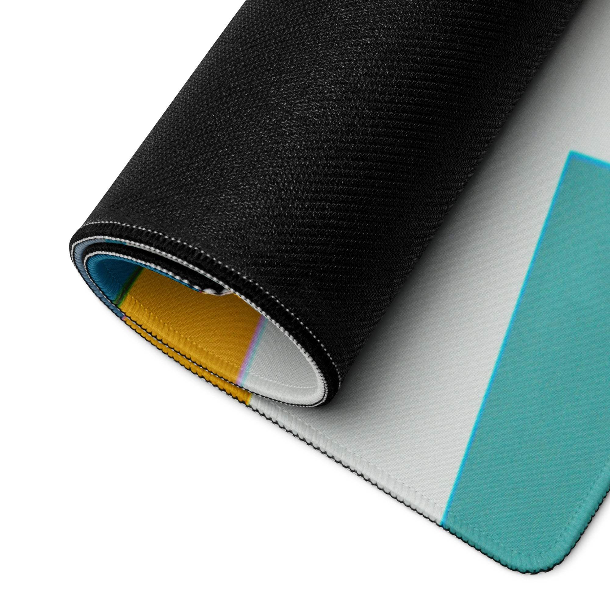 Large colorful abstract geometric gaming mouse pad with black textured rolled edge revealing colorful layers and stitched seams