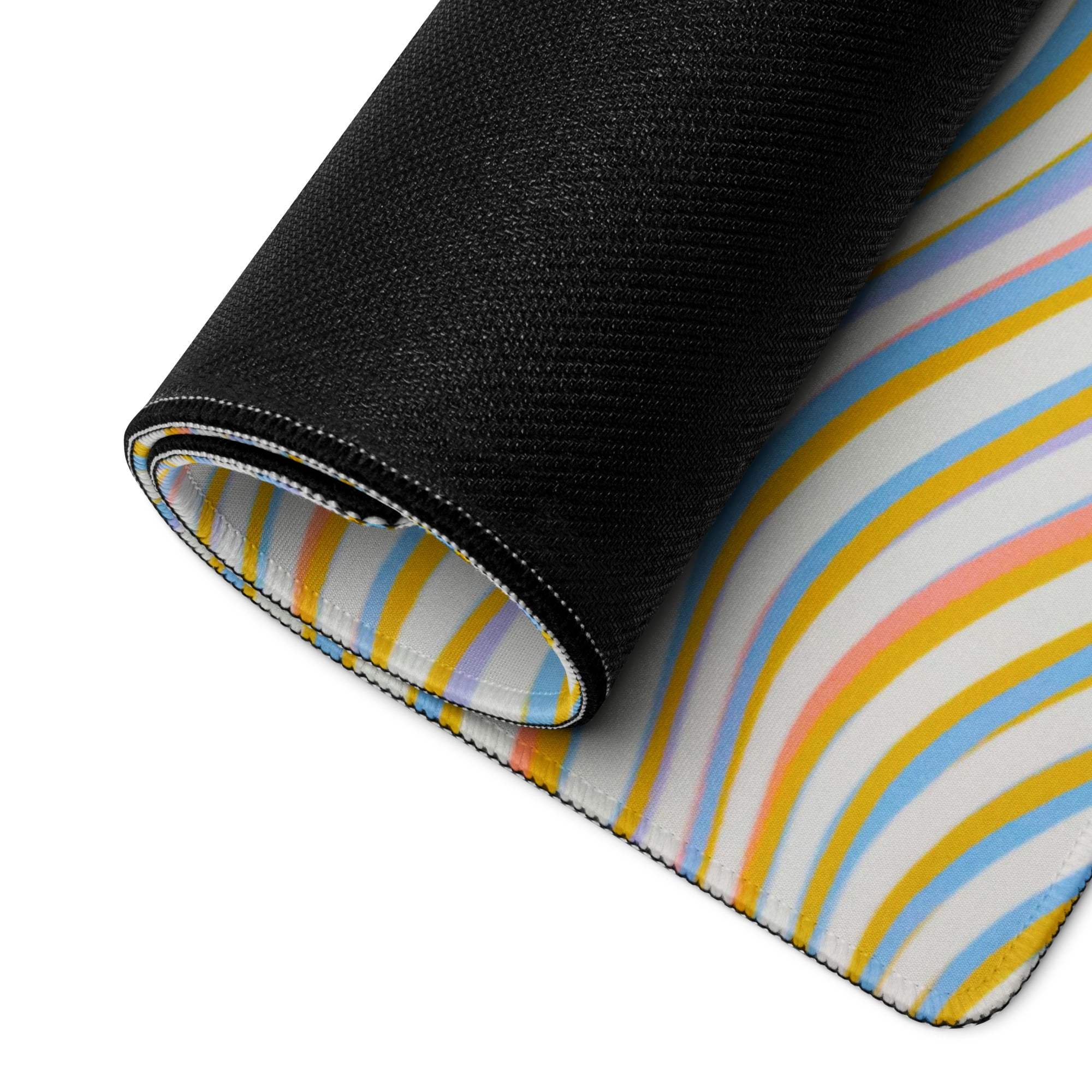 Rolled-up vibrant wavy rainbow mouse pad with non-slip base on white background
