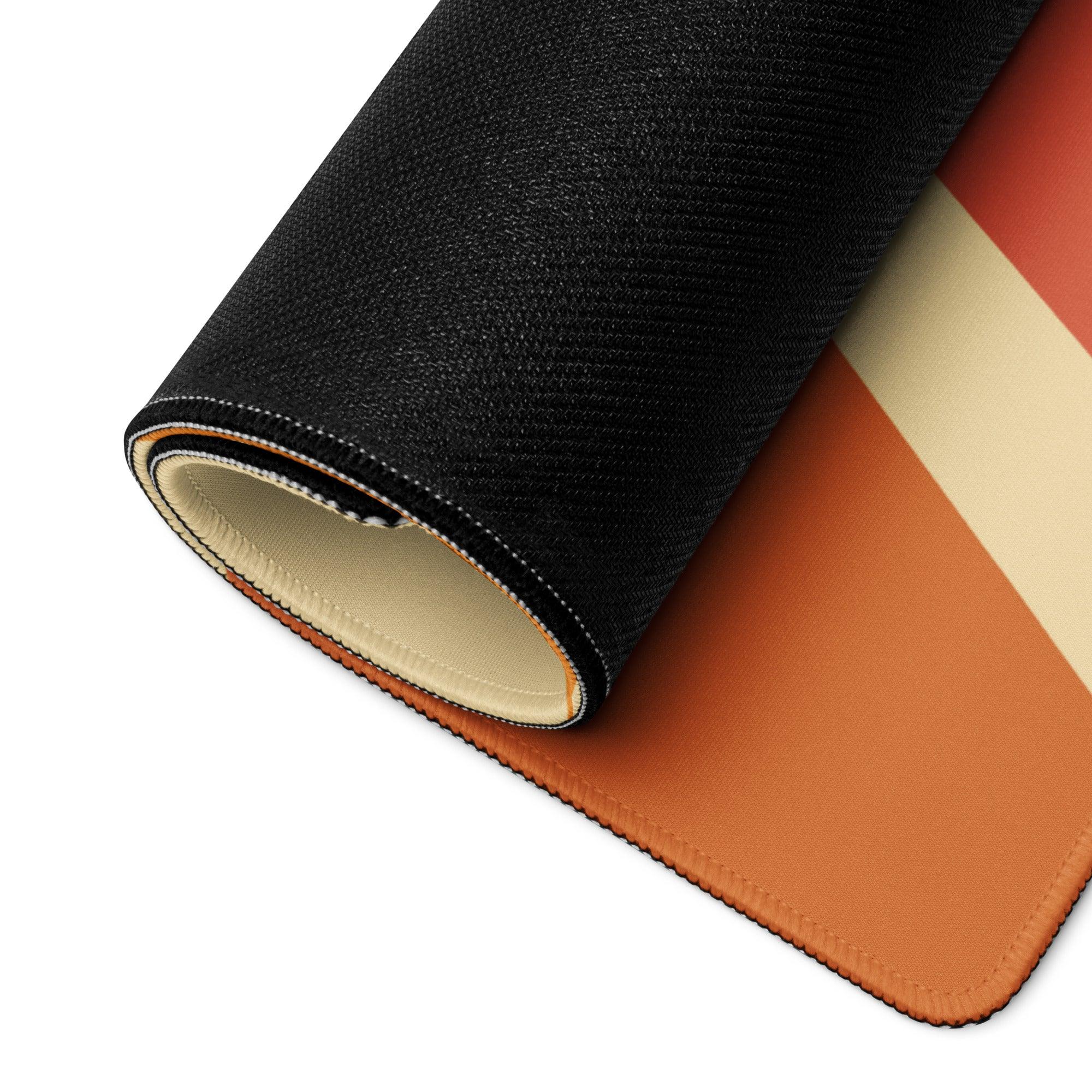 Rolled black textured gaming mousepad with orange cream stripes showing layered build