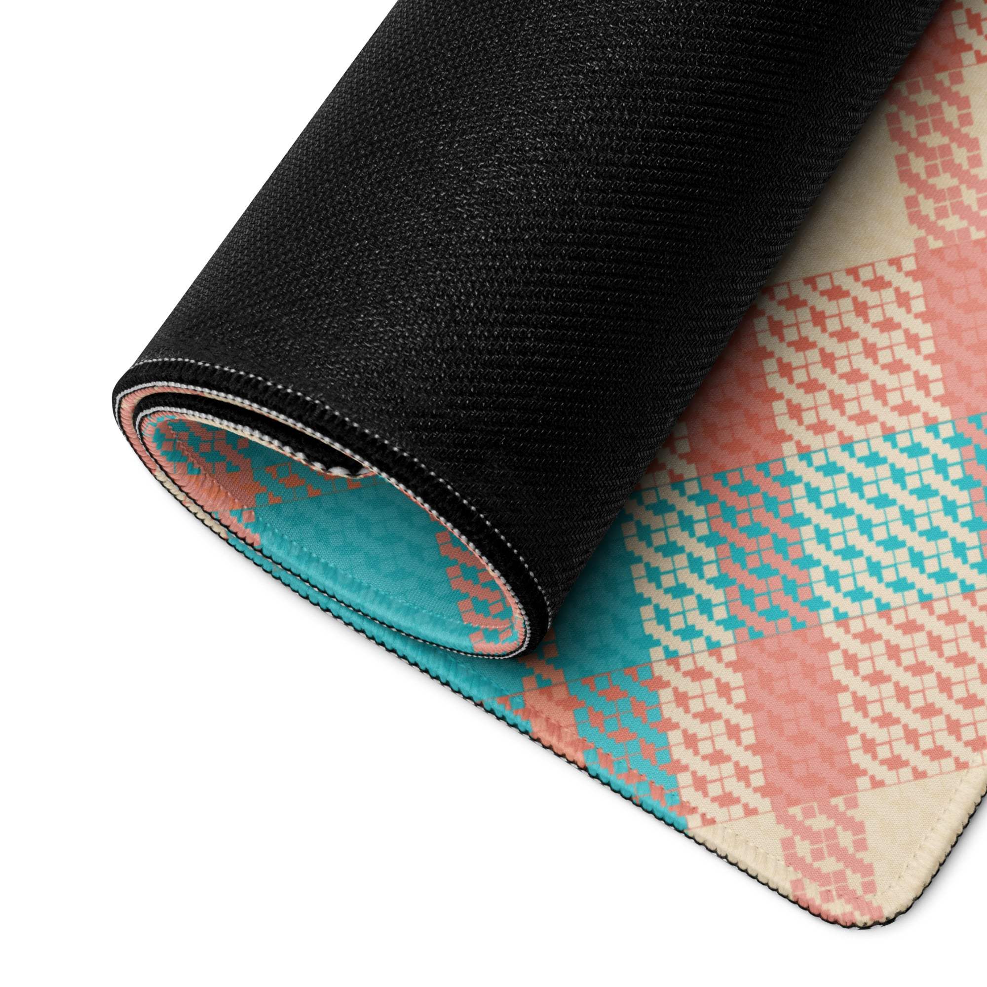Rolled-up gaming mouse pad backside with black textured backing and vibrant teal peach plaid pattern