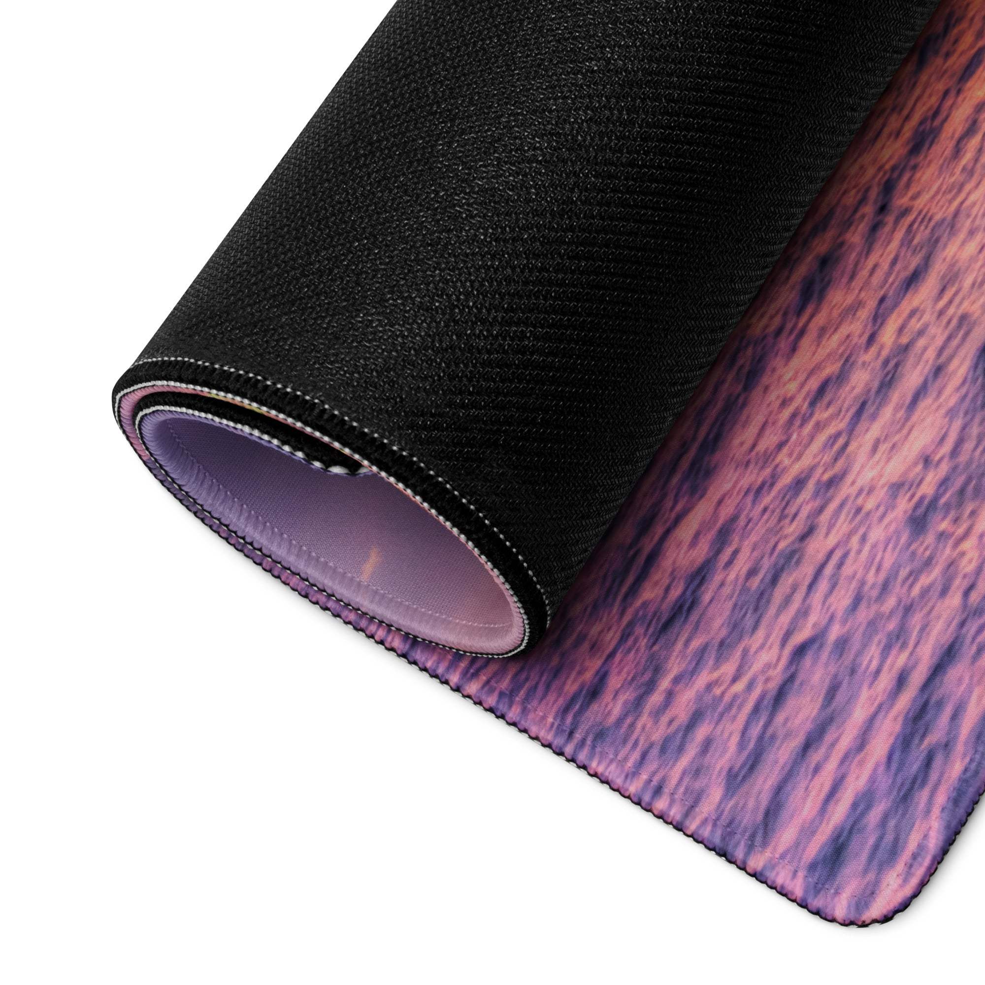 Rolled-up Sunset Ocean Vibe gaming mouse pad with purple pink wood-grain design