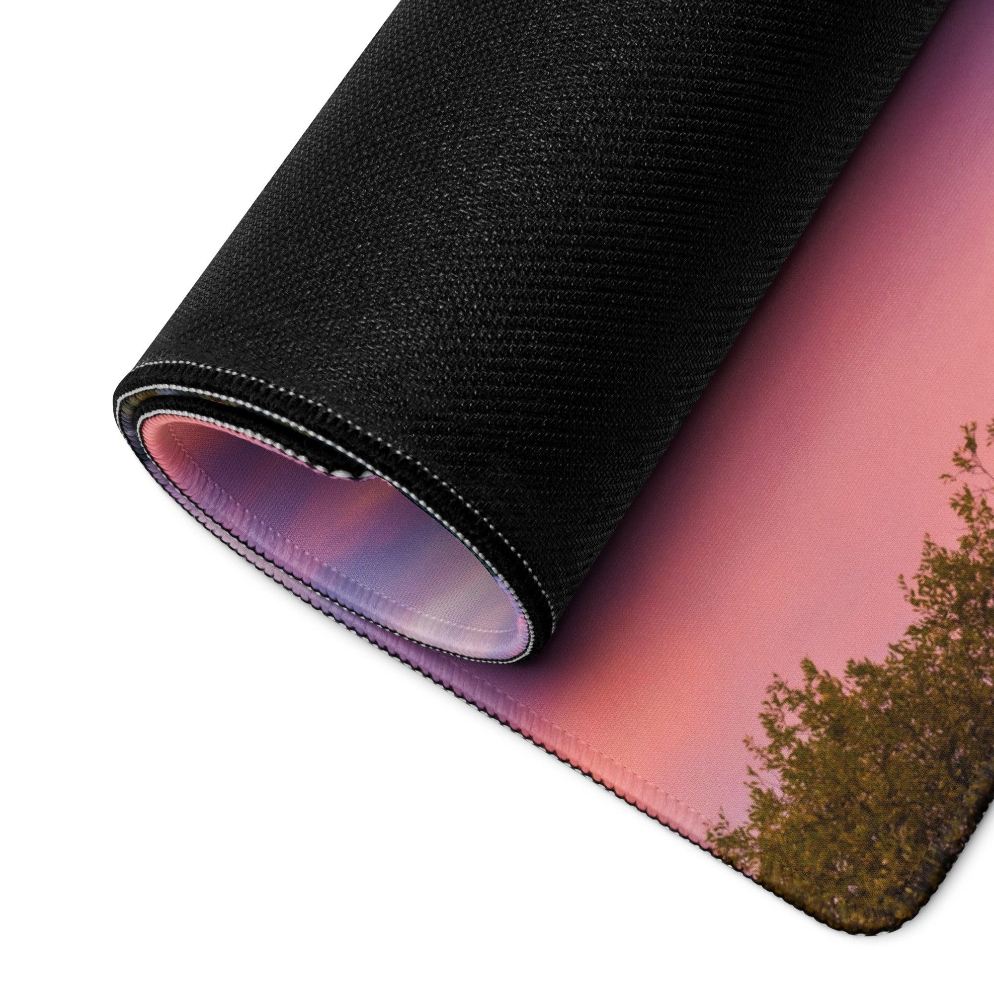 Rolled-up Vibrant Mountain Sunrise mouse pad with pink sunset over trees