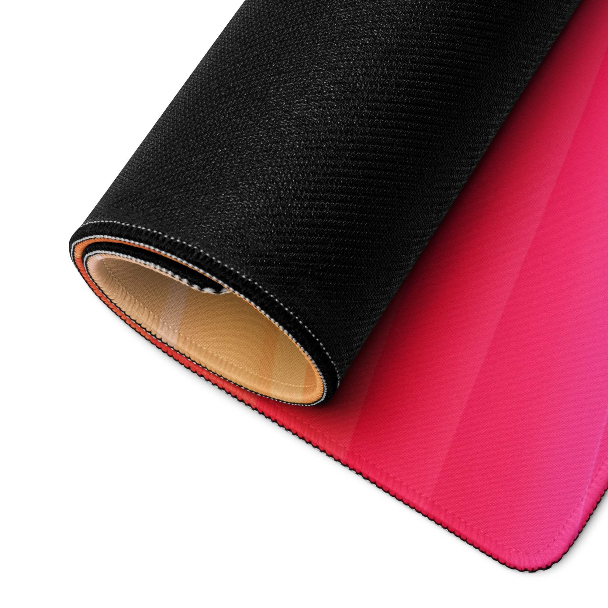 Rolled-up vibrant sunset gradient gaming mouse pad with pink texture and stitching