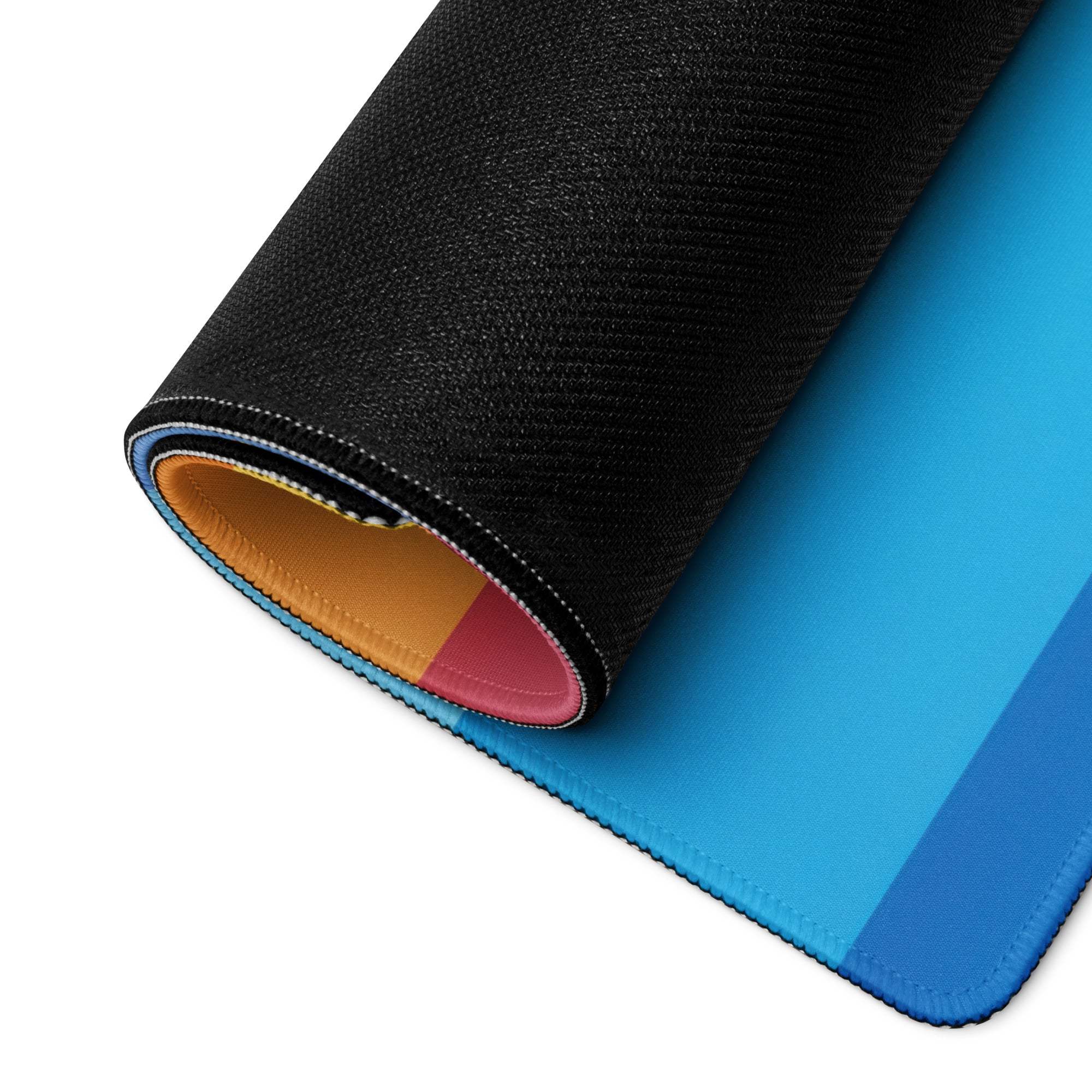 Large rainbow gradient gaming mouse pad with blue gradient, black textured edge, colorful lining, non-slip base, durable stitching