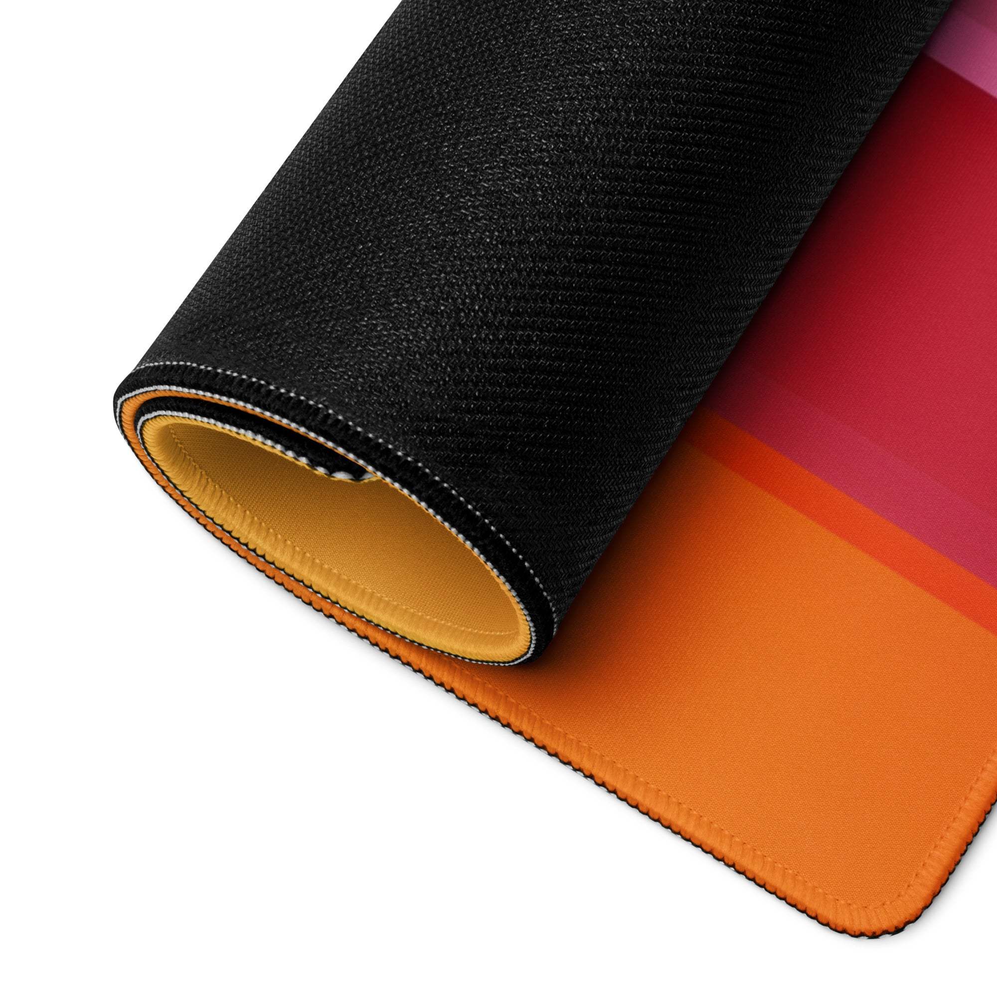 Rolled-up Vibrant Rainbow Stripe gaming mouse pad with orange-pink gradient, non-slip base, edge stitching