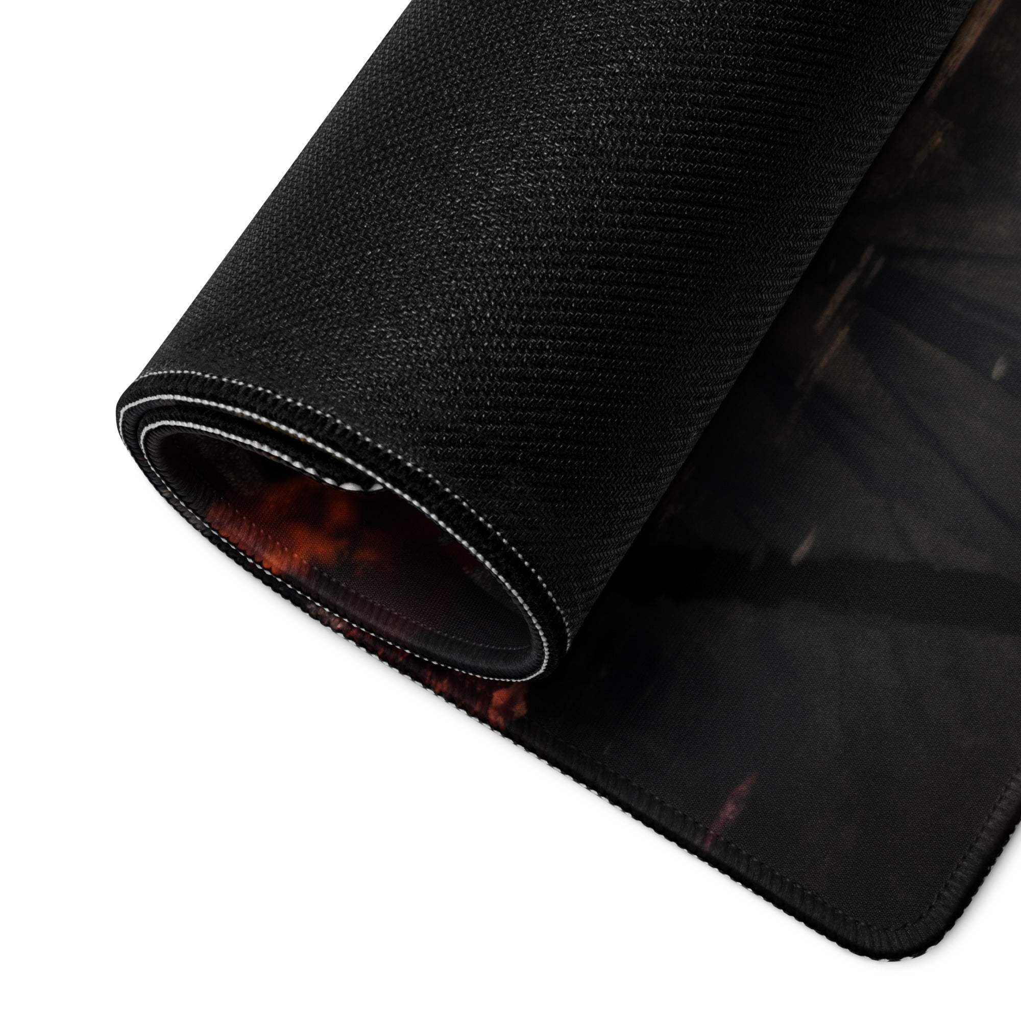 Black textured gaming mousepad with rolled edge and red-orange Autumn Forest graphic seam