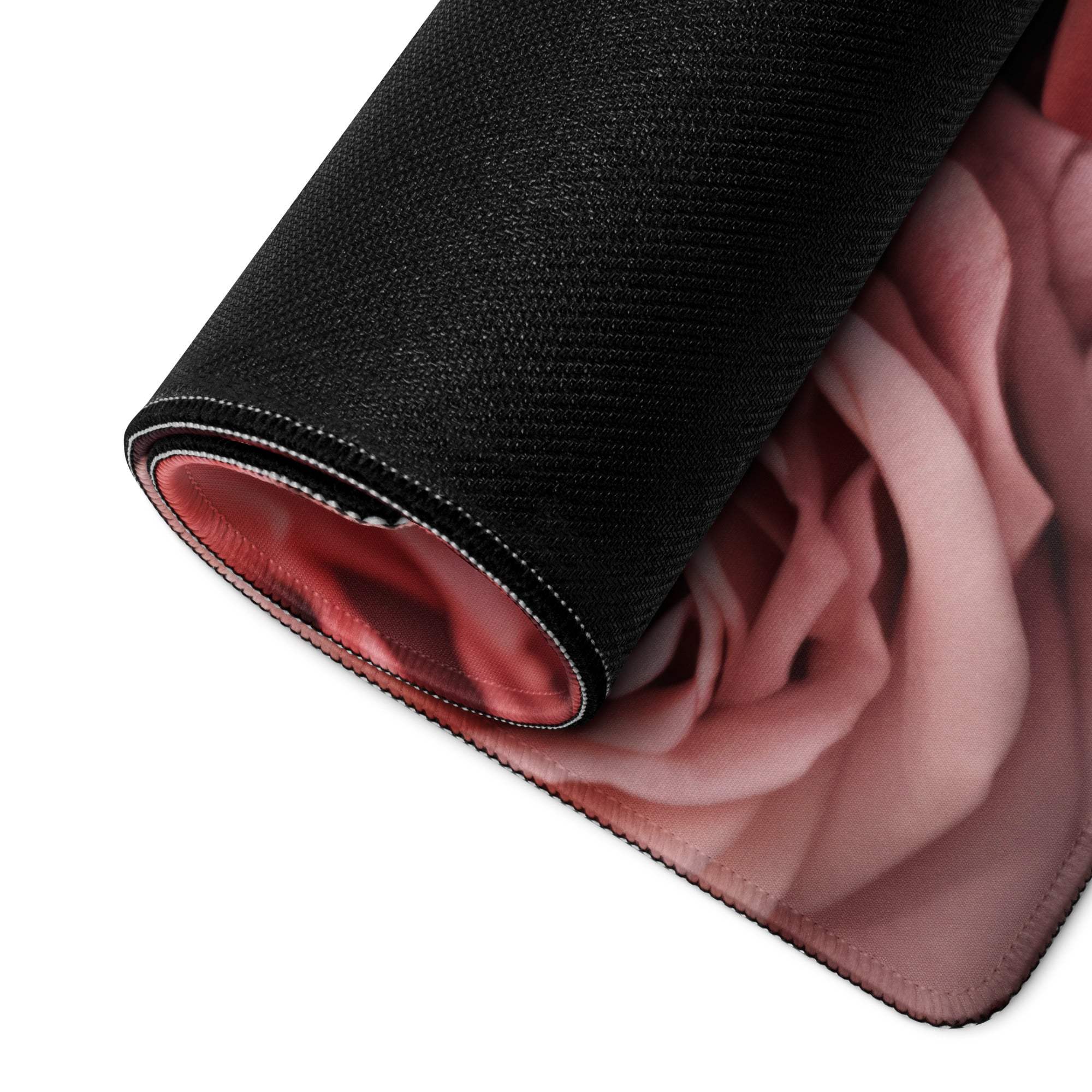 Black gaming mousepad with rolled edge revealing pink rose design
