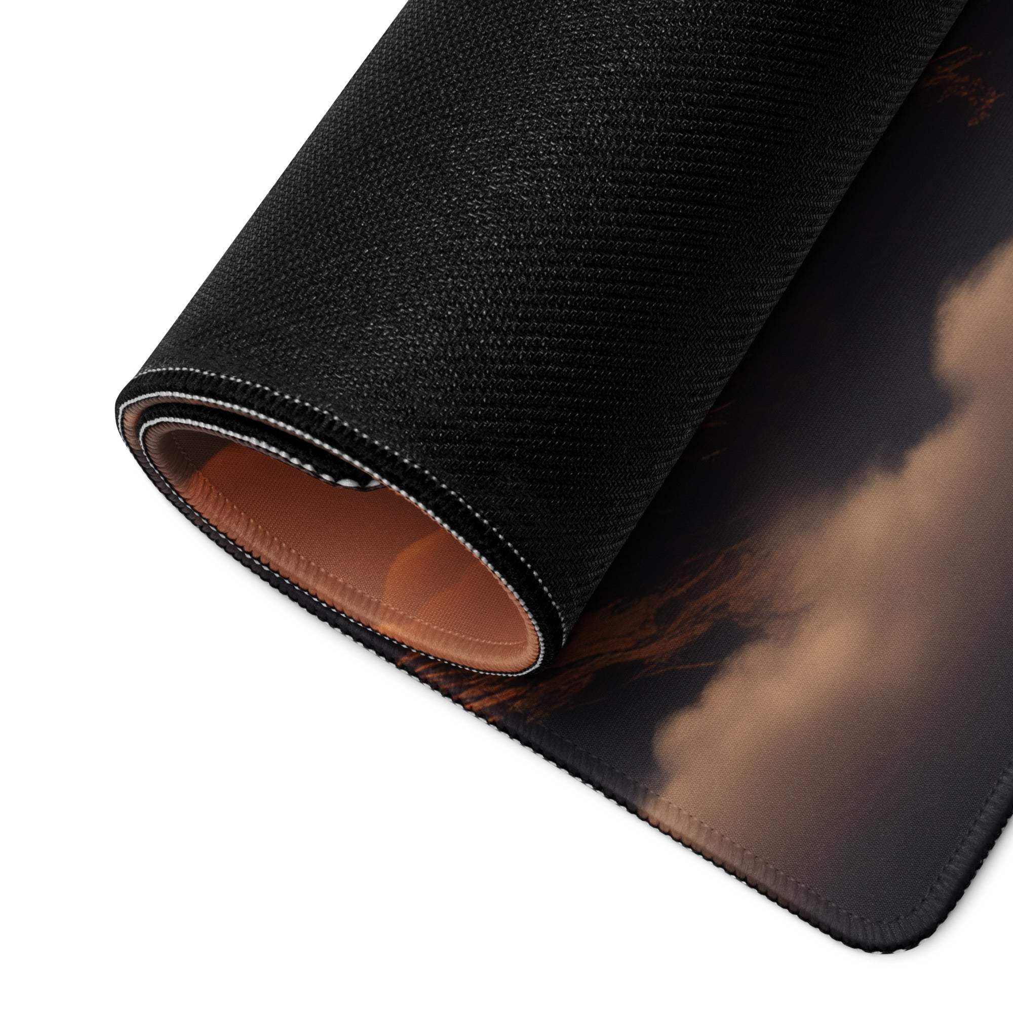 Rolled Epic Mountain Sunset gaming mouse pad showing stitched edge and brown lining