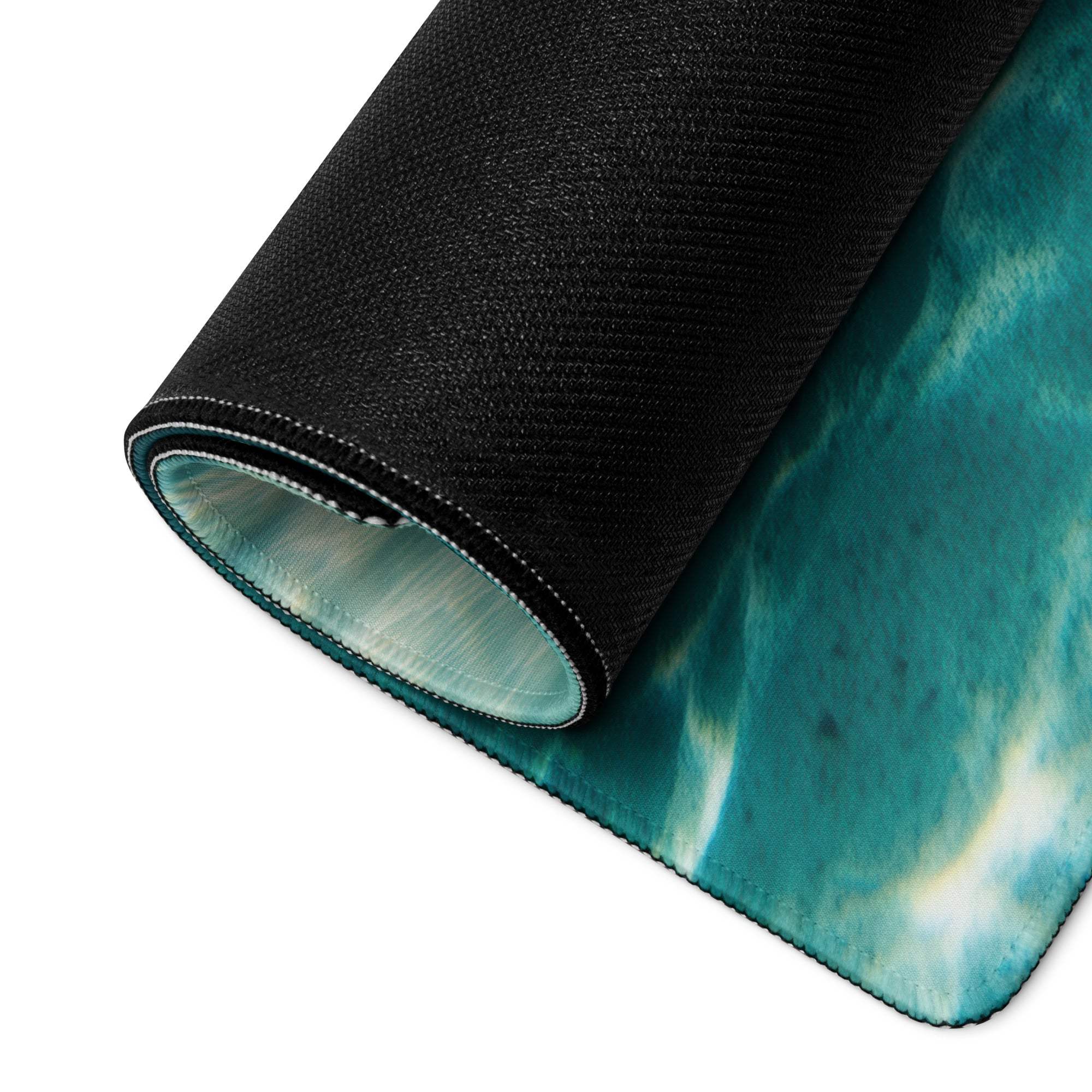 Rolled-up underwater ocean gaming mouse pad with teal white design and black underside