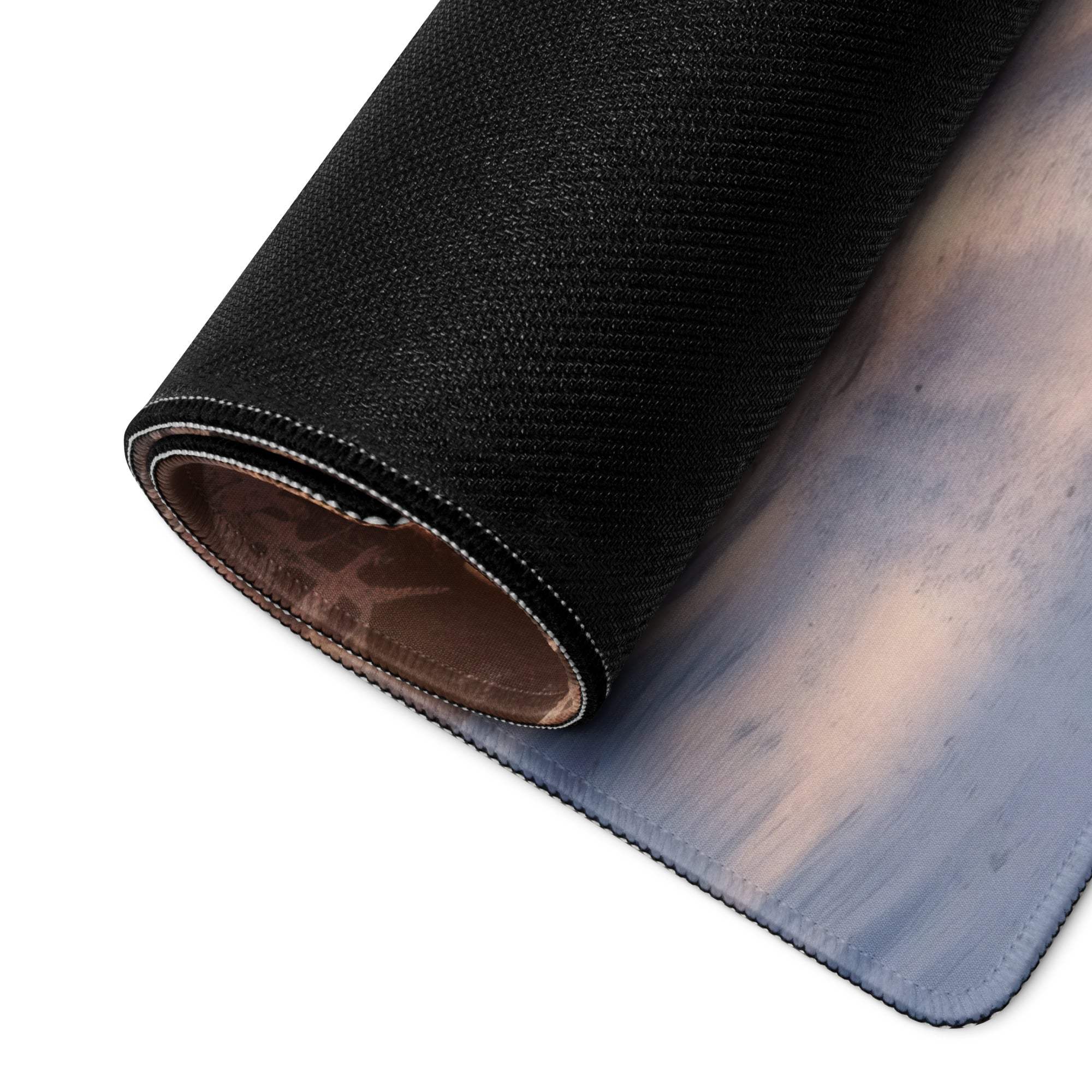 Black textured mousepad with blue-gray gradient and stitched edge, rolled view