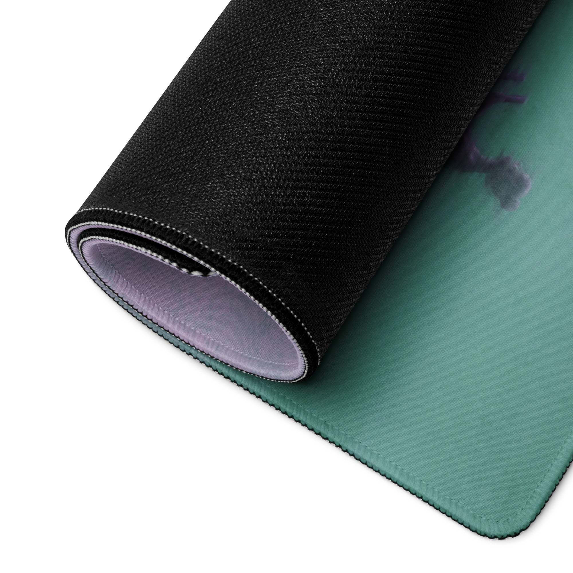 Teal-colored gaming mousepad with black textured outer layer and stitched edges for a modern desk setup