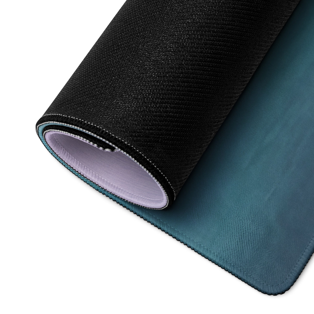 Black textured outer surface with teal inner layer of McLaren P1 inspired volcanic sunset extended desk pad rubber base