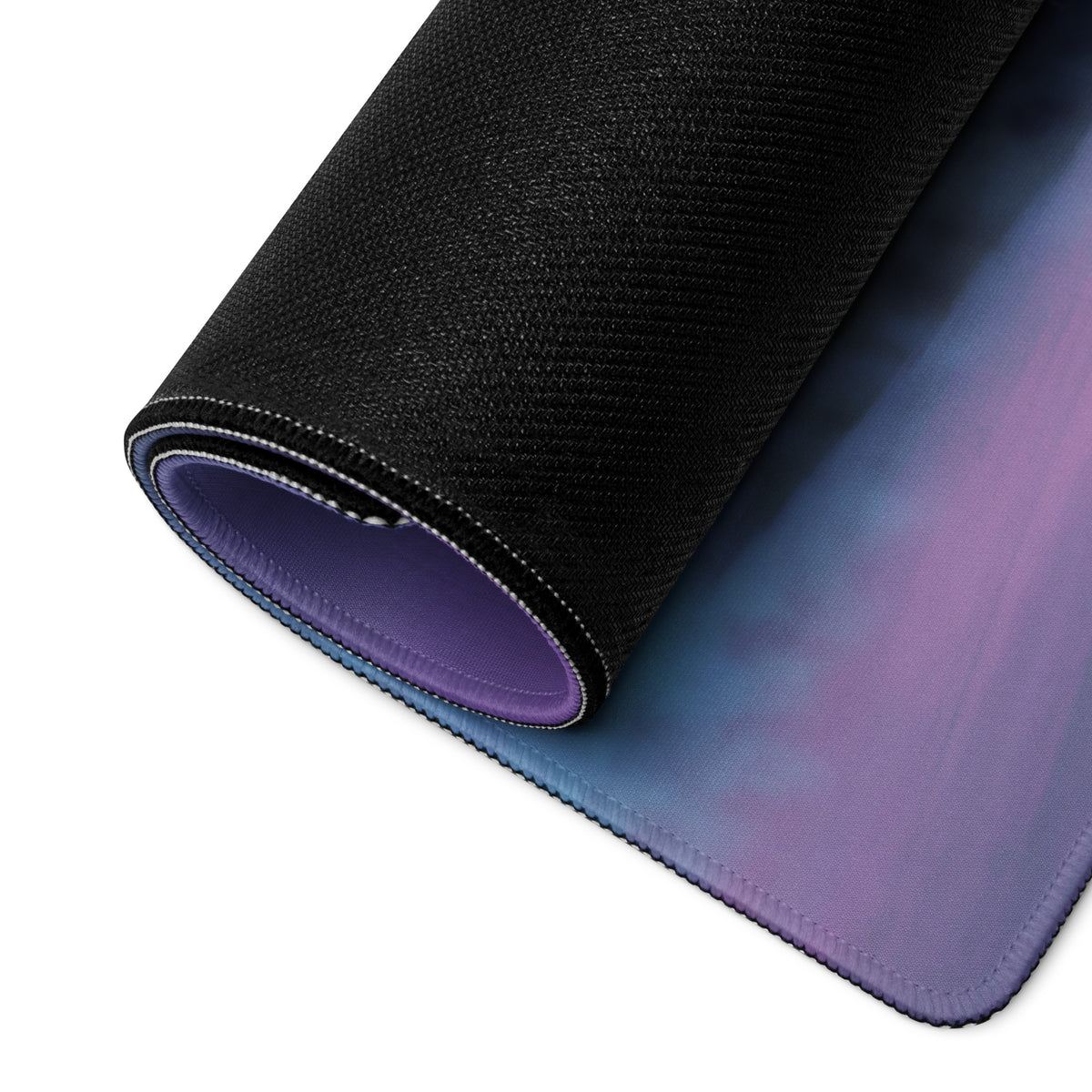 A rolled-up ferrari 488 inspired pearl white desk pad with gradient purple blue surface and stitched edges mouse mat