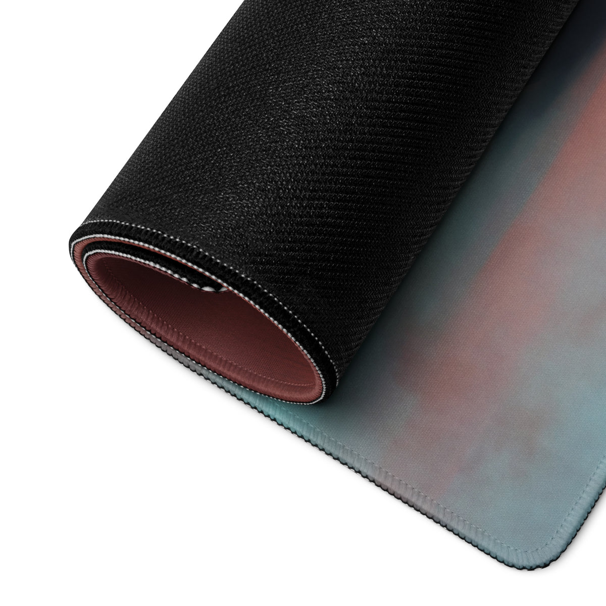 A rolled-up Kawasaki Ninja H2 inspired extra large desk pad mousepad with teal to pink gradient and stitched edges