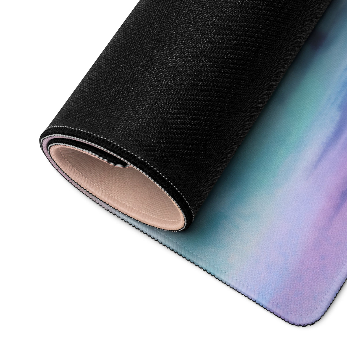 A rolled-up concept motorcycle extended desk pad with teal to purple gradient surface and stitched black edges for gamers
