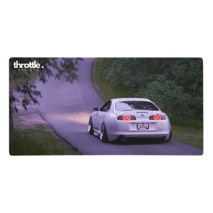 Extended gaming mouse pad featuring a white Toyota Supra Mk4 driving on a forest road at dusk.