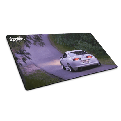 Large gaming mouse pad featuring a silver Toyota Supra Mk4 driving on a winding road with greenery background.