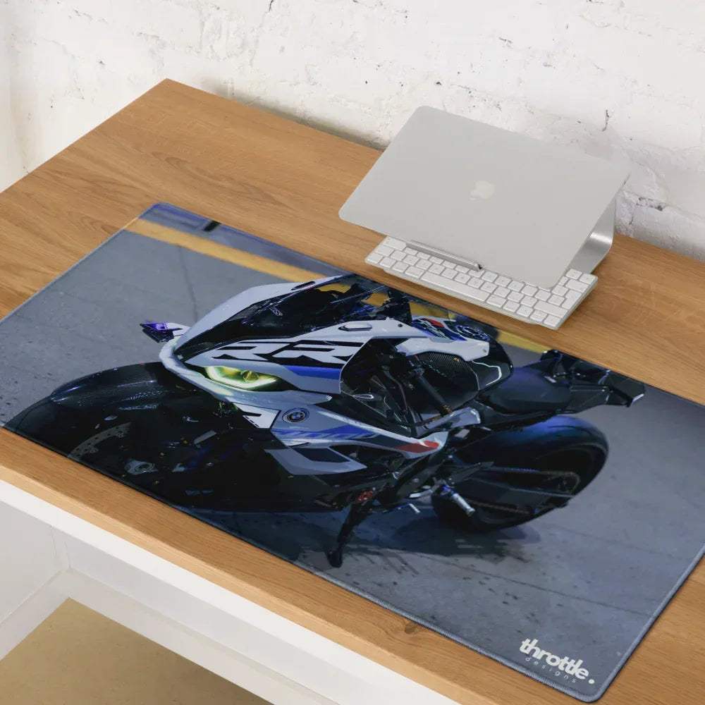 A large BMW inspired S1000RR gaming mouse pad with a white and blue motorcycle and glowing yellow headlights