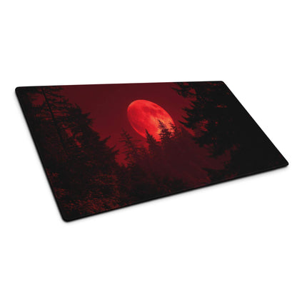 Dark red moon over pine trees on large gaming mouse pad