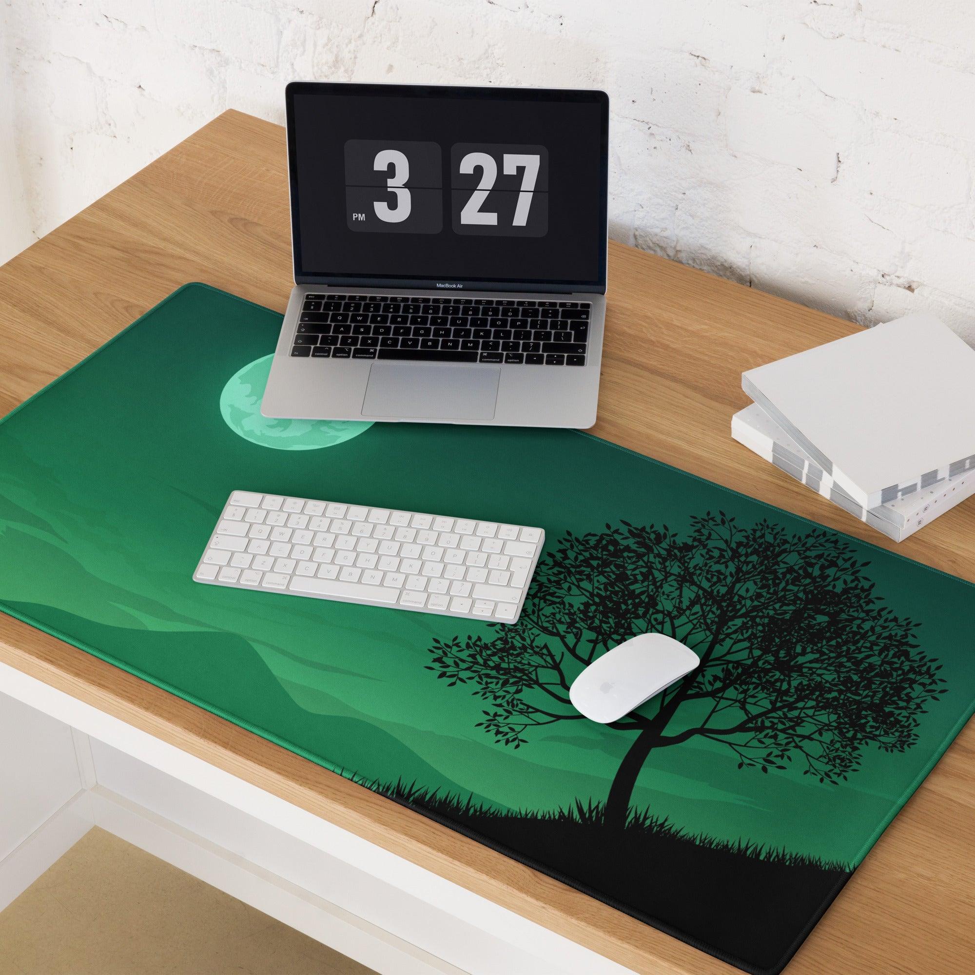 Green rectangular gaming mousepad with black tree silhouette under moon