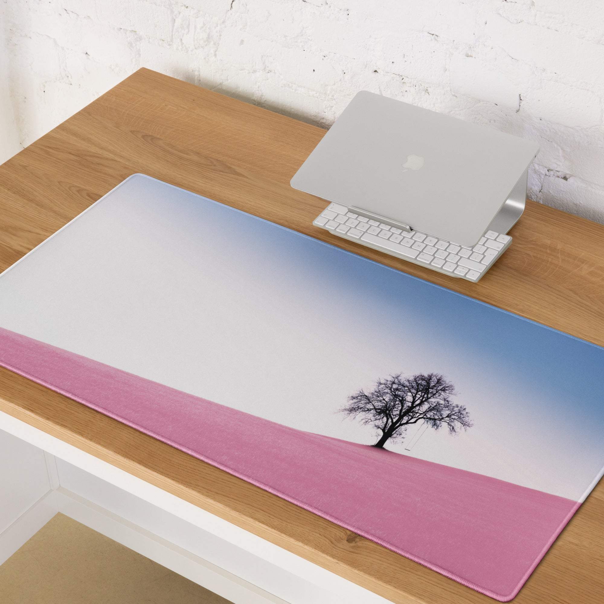Large pastel pink gaming mouse pad with blue gradient, black tree silhouette