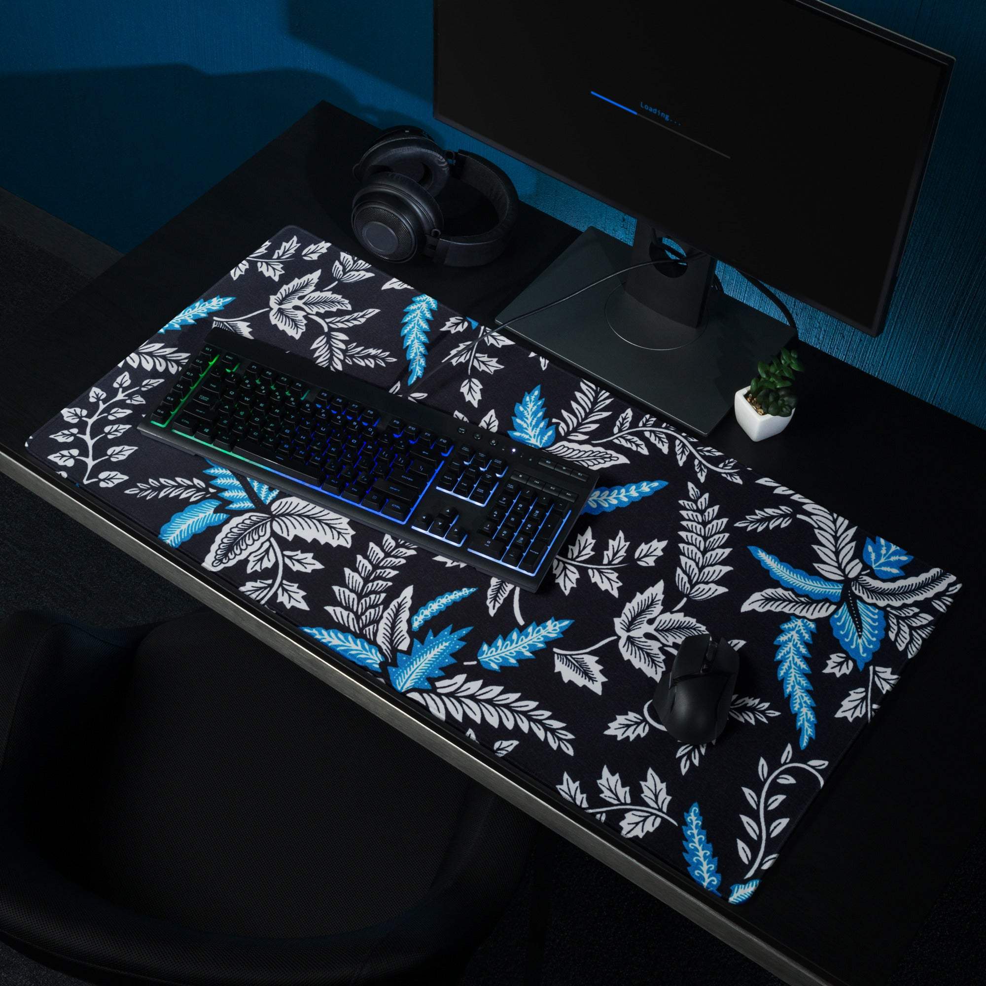 Large black gaming mouse pad with vibrant blue white botanical leaf pattern