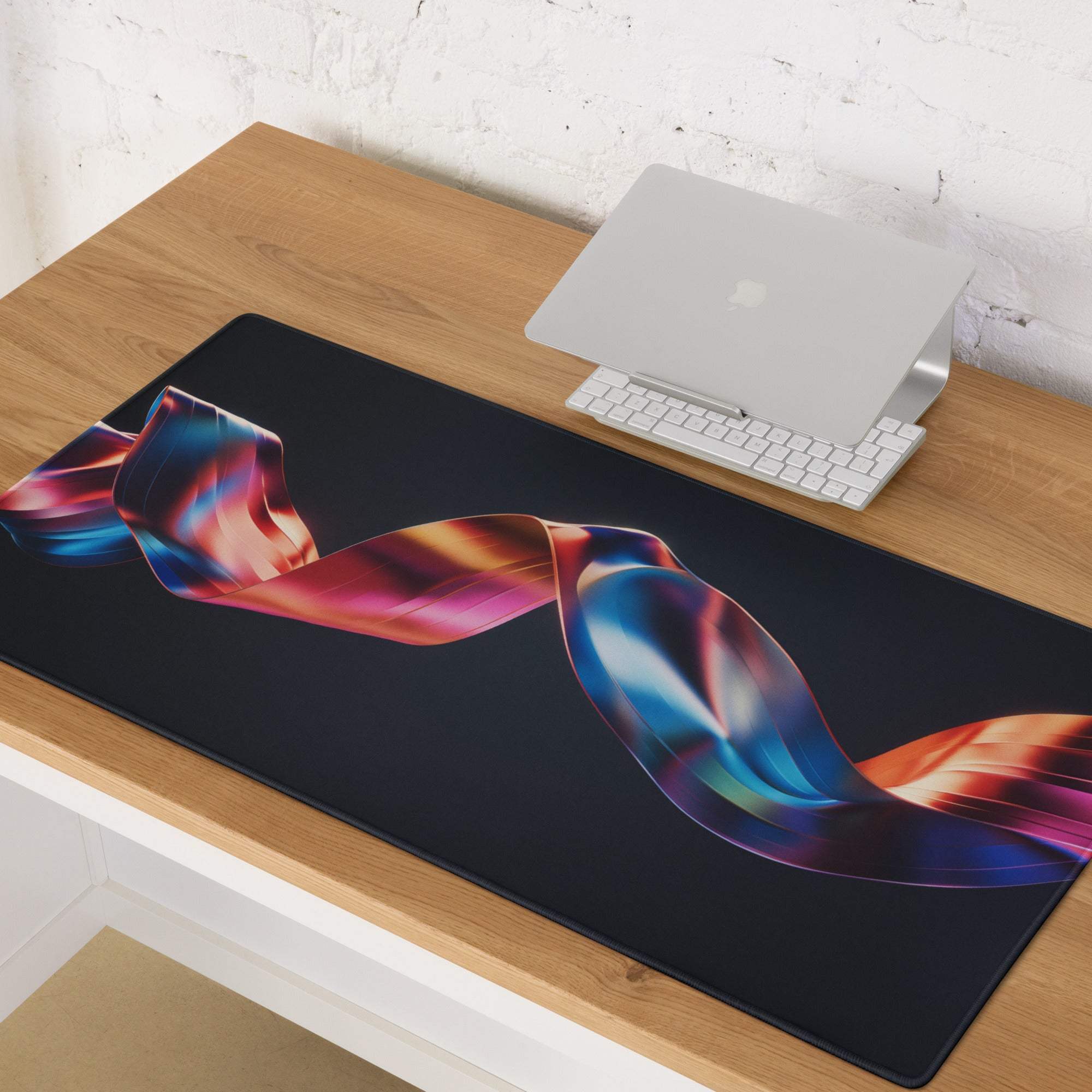 Black rectangular gaming mousepad with iridescent ribbon in blue, pink, orange