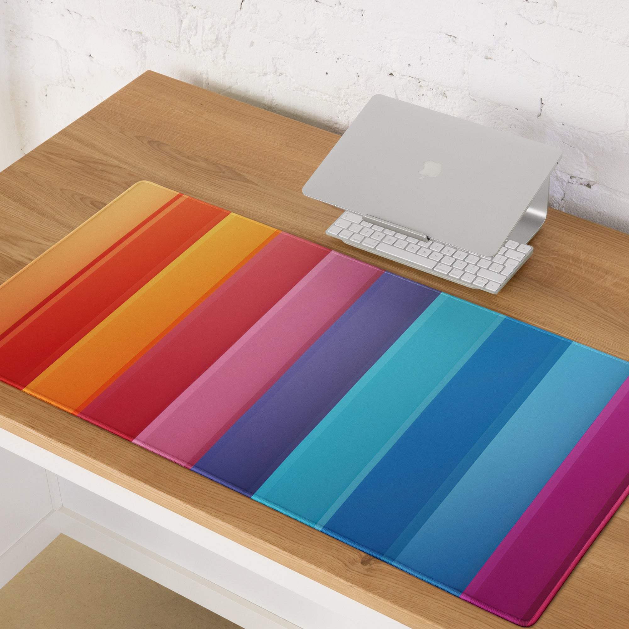 Vibrant rainbow-striped silicone desk mat with glossy finish and non-slip base