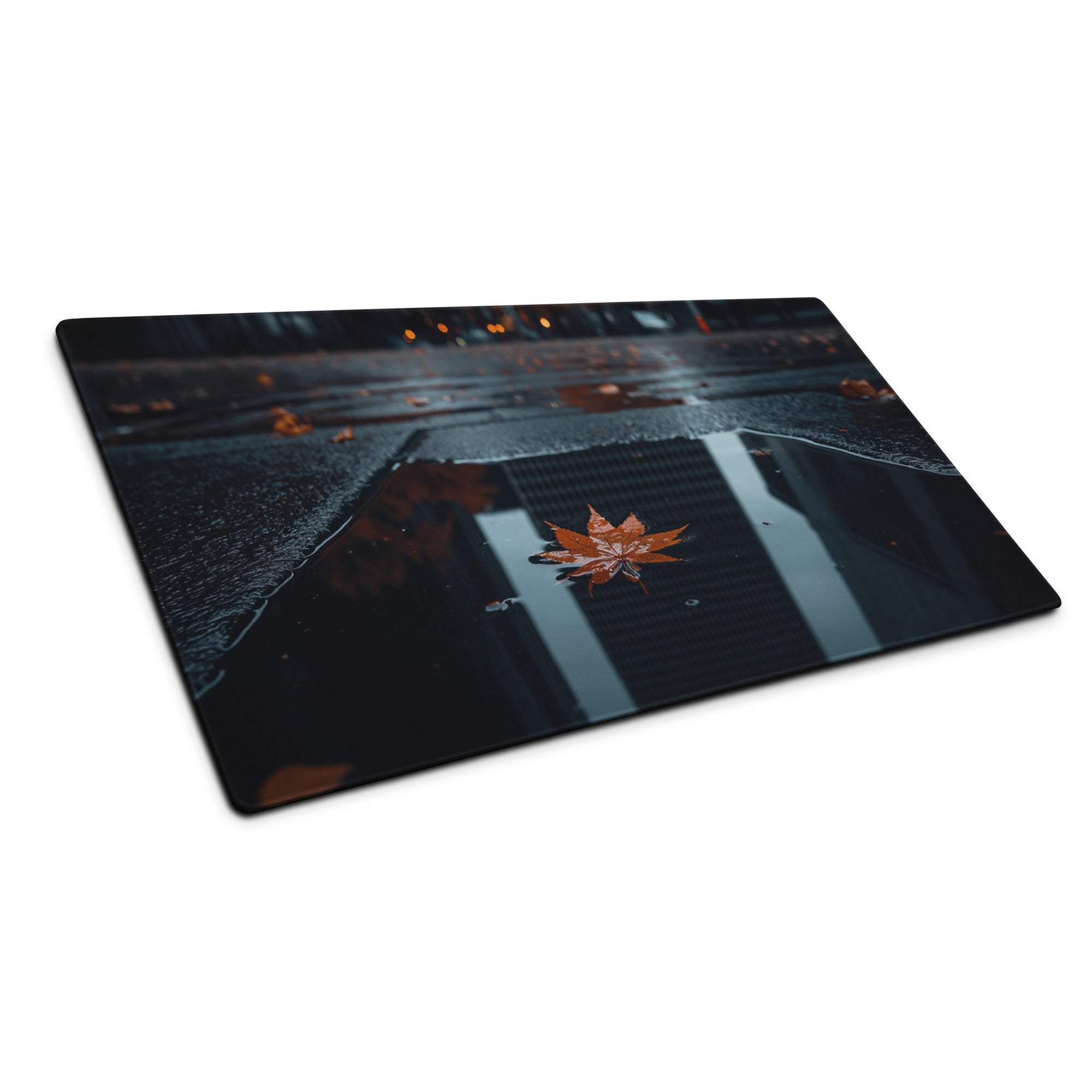 Moody urban night desk mat with orange maple leaves in rain puddle