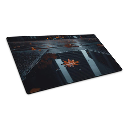 Moody urban night desk mat with orange maple leaves in rain puddle