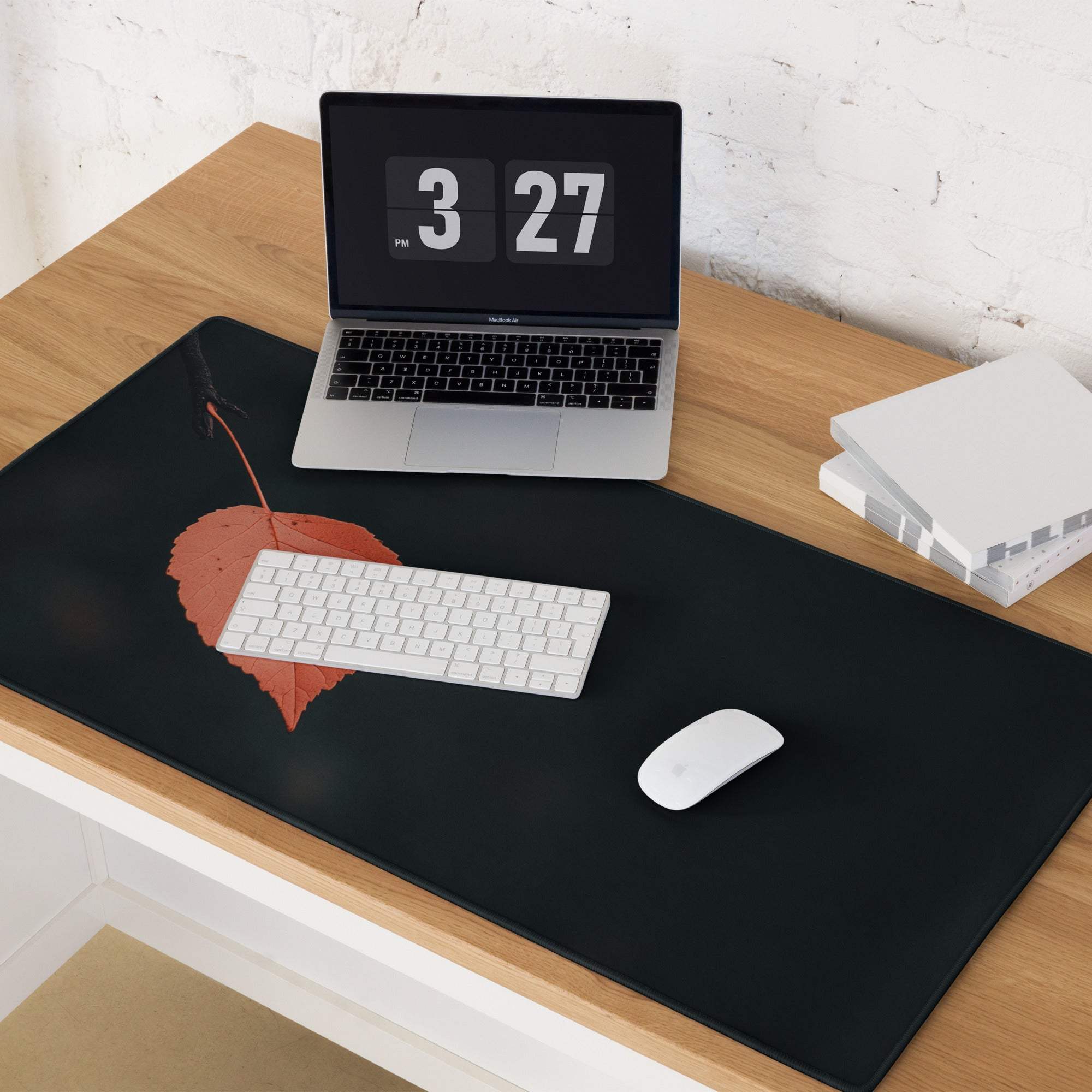Black desk mat with red leaf design, non-slip base, stitched edge