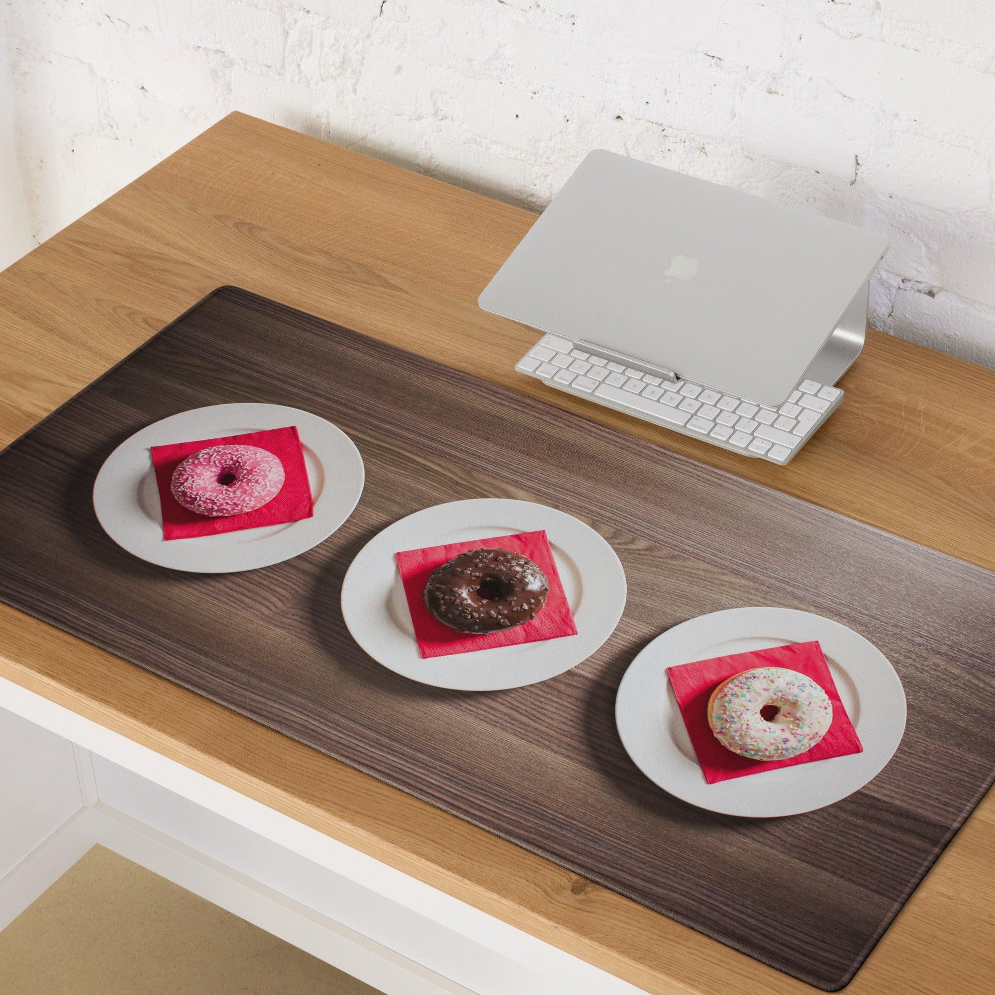 Three donuts on red napkins atop white plates on wood grain gaming mouse pad