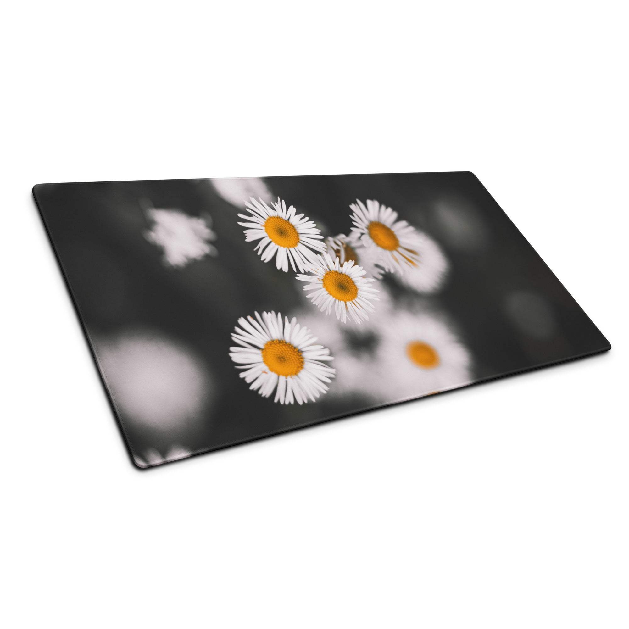 Black glass cutting board with white daisy print on blurred background