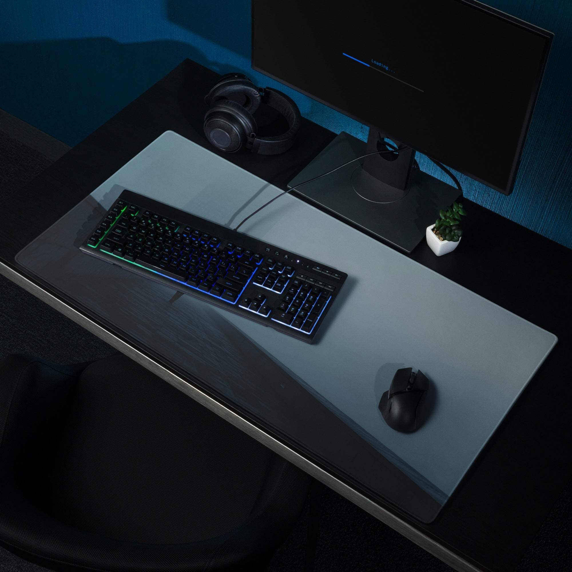 Black RGB gaming keyboard on Moody Blue Mist mouse pad desk setup