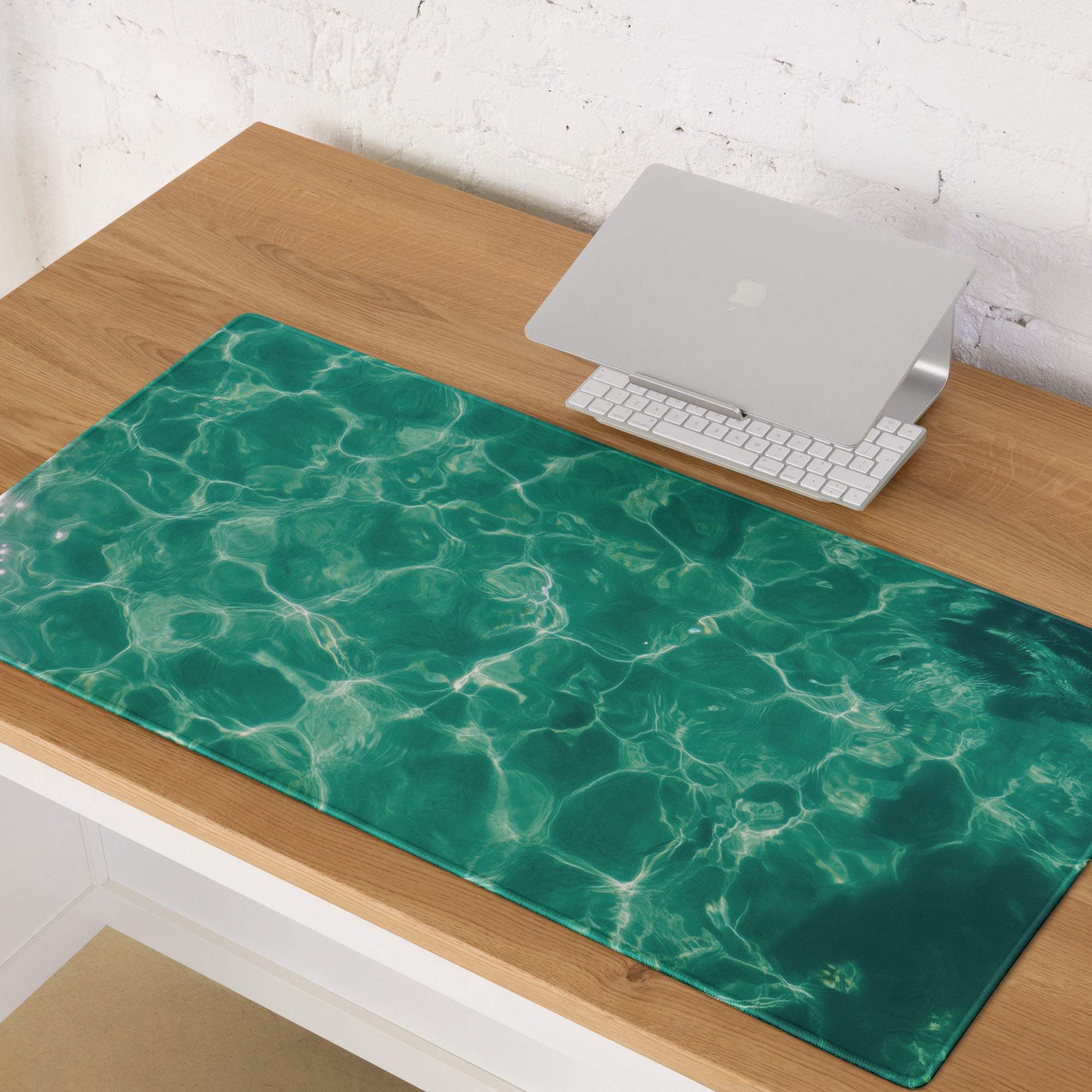 Emerald green ripple desk mat with glossy ocean wave print and non-slip base