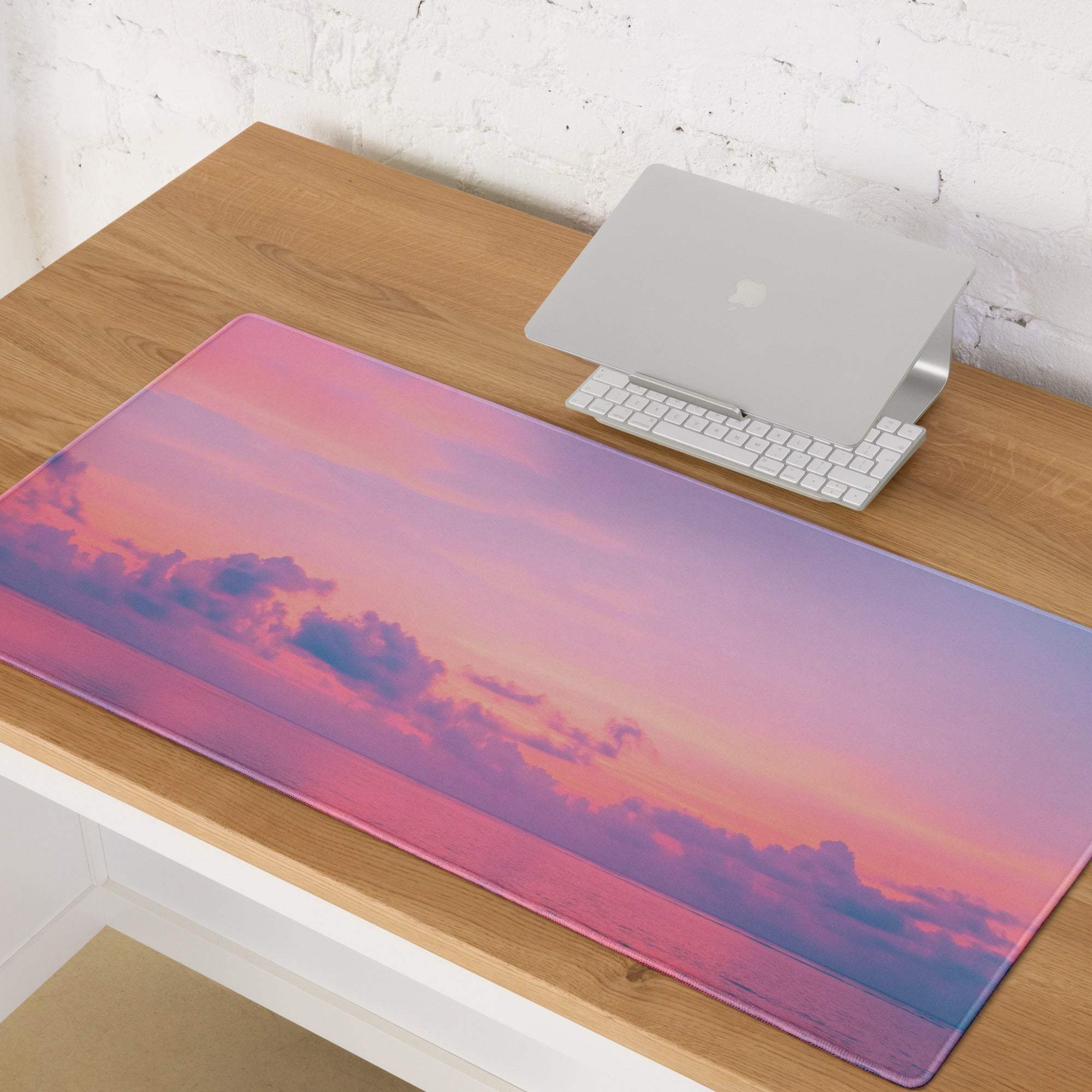 Dreamy sunset gradient pink purple gaming mouse pad on wooden desk