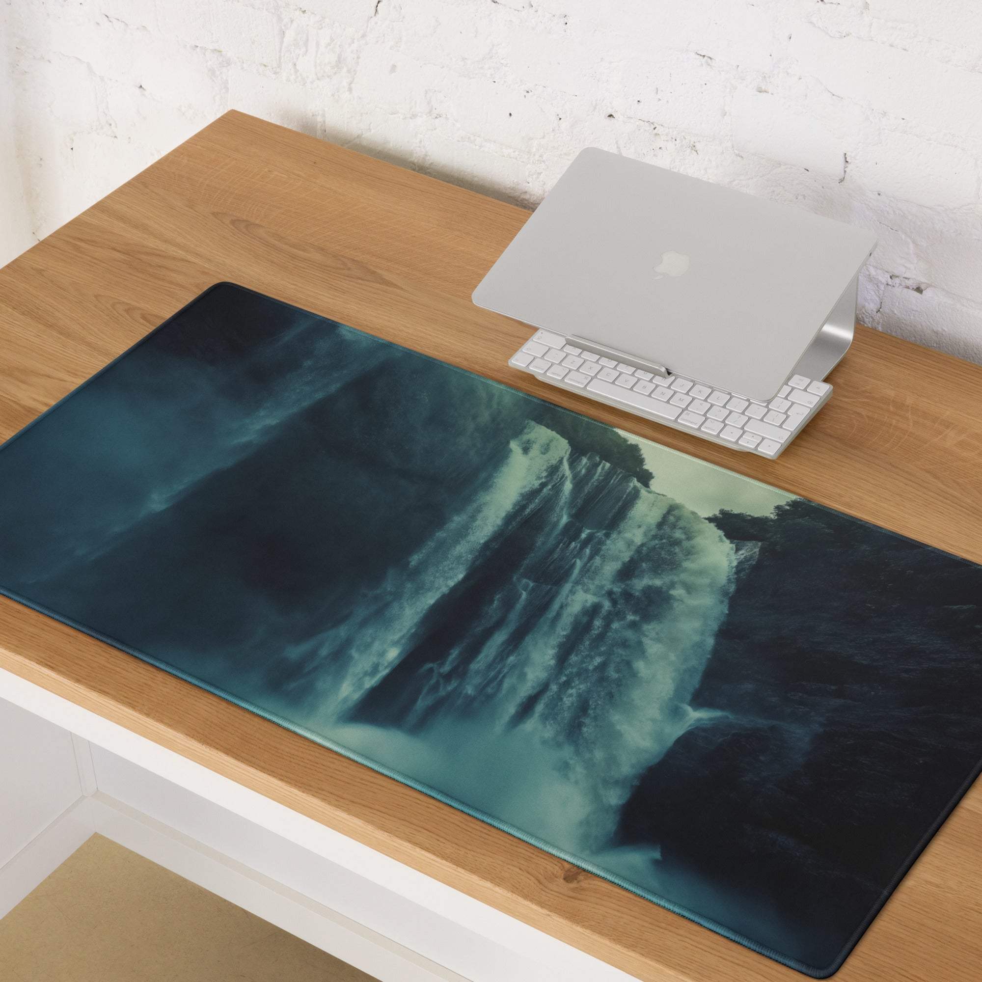 Epic Waterfall Scene moody blue gaming mousepad on wooden desk