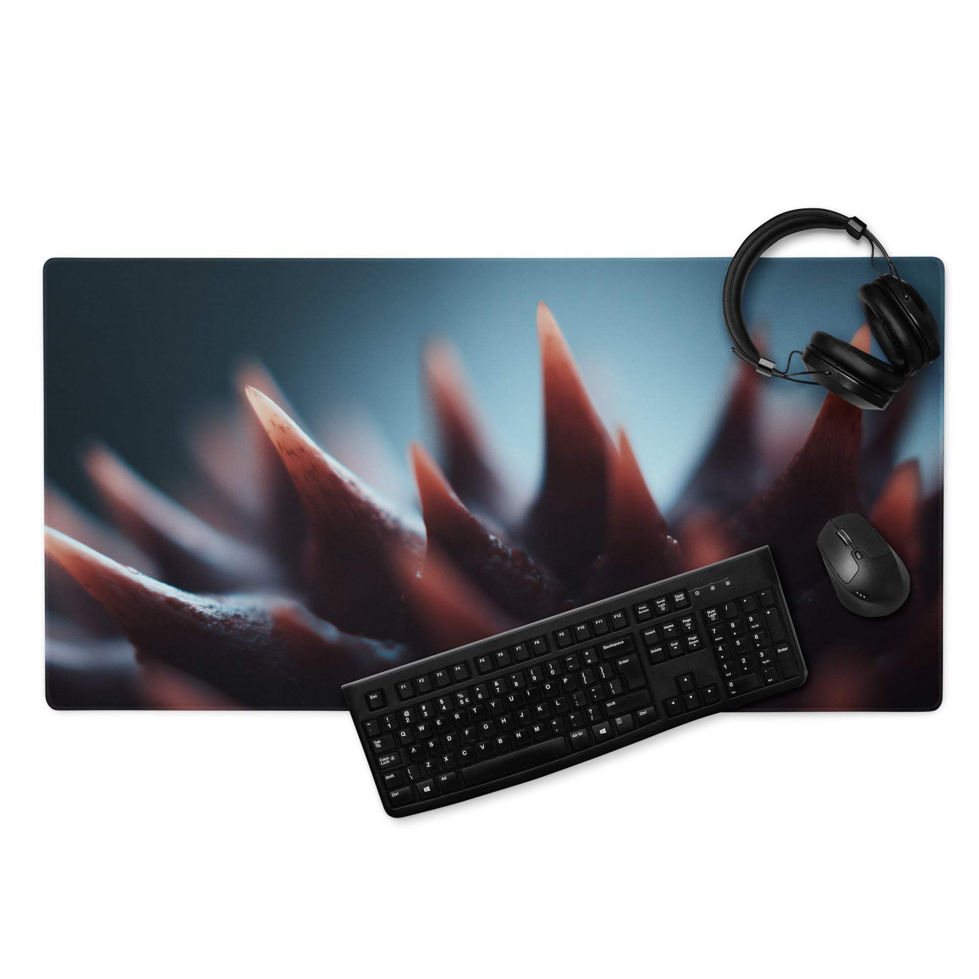 Black keyboard and mouse on Moody Blue And Red spiked gaming mouse pad