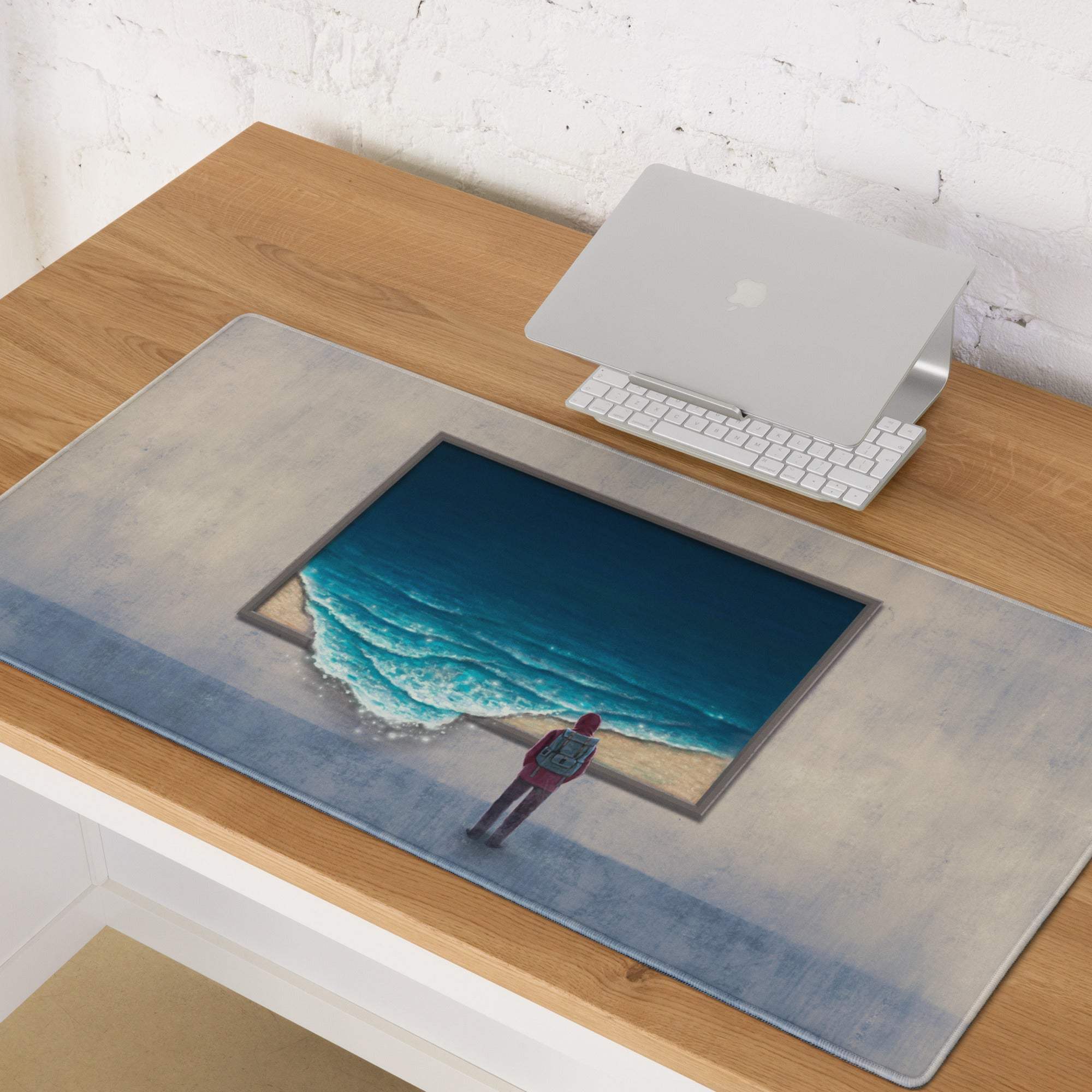 Rectangular coastal beach ocean desk pad with surreal blue waves and lone figure on sand framed by gray border