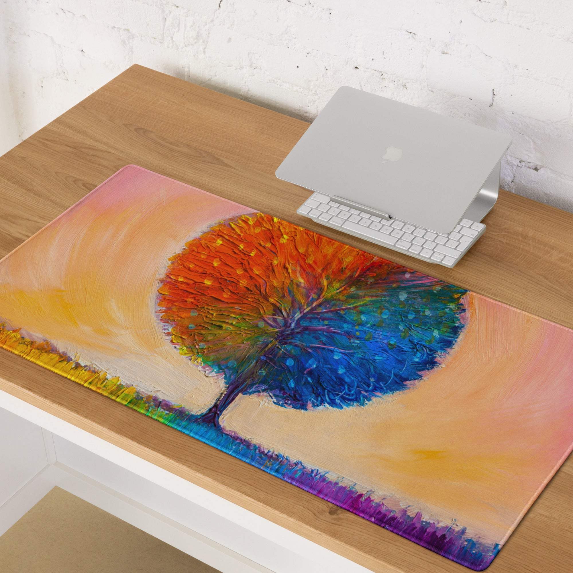 A vibrant rectangular mousepad with a colorful abstract tree design in orange and blue on a gradient background