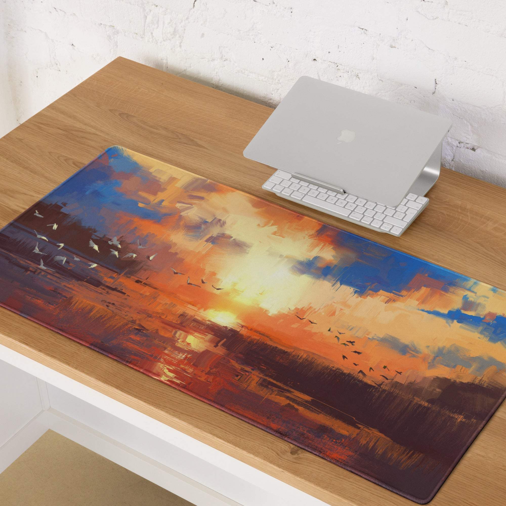 Sunset abstract gaming desk mat featuring vibrant orange and blue painterly sunset with bird silhouettes and reflective water