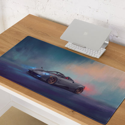 A sleek dark gray pagani huayra sports car graphic on a large stitched edge desk pad with blue and orange smoke effects
